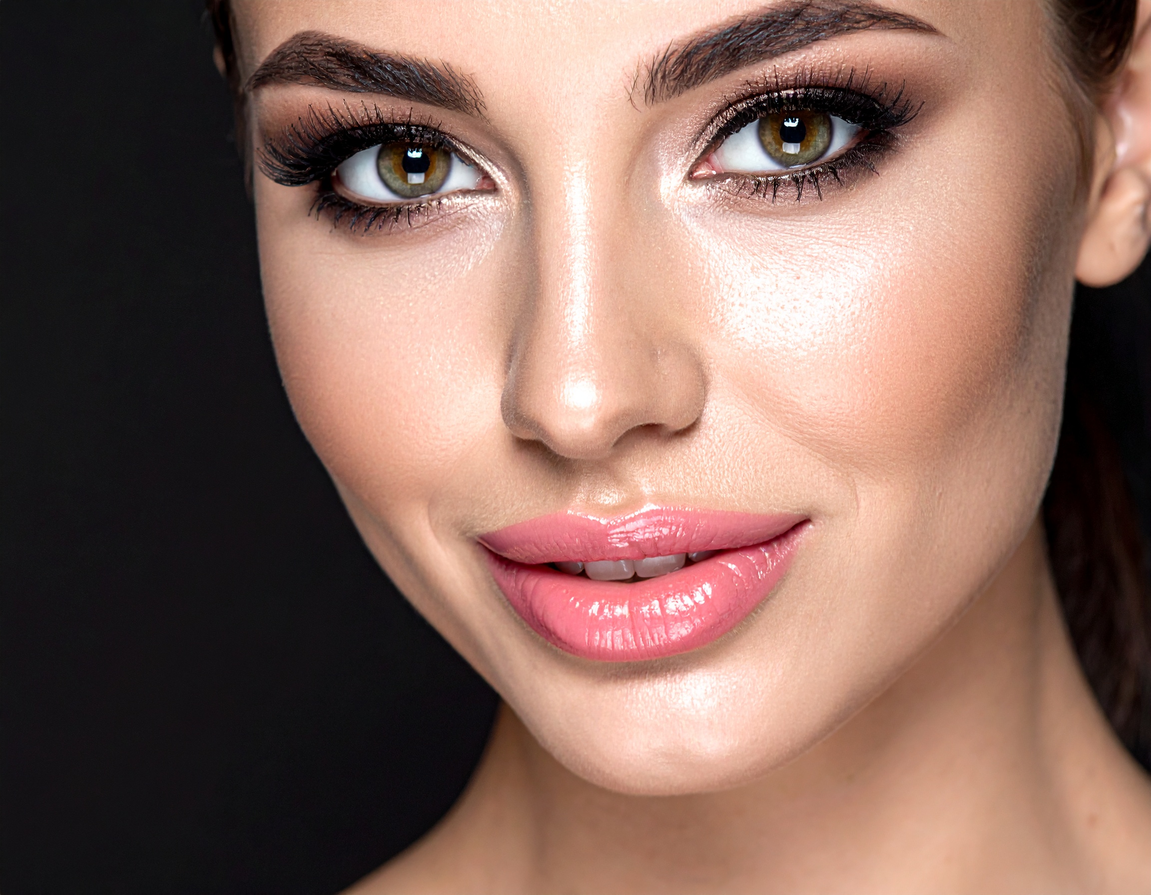 Close-up of a woman's face highlighting flawless skin and vibrant makeup