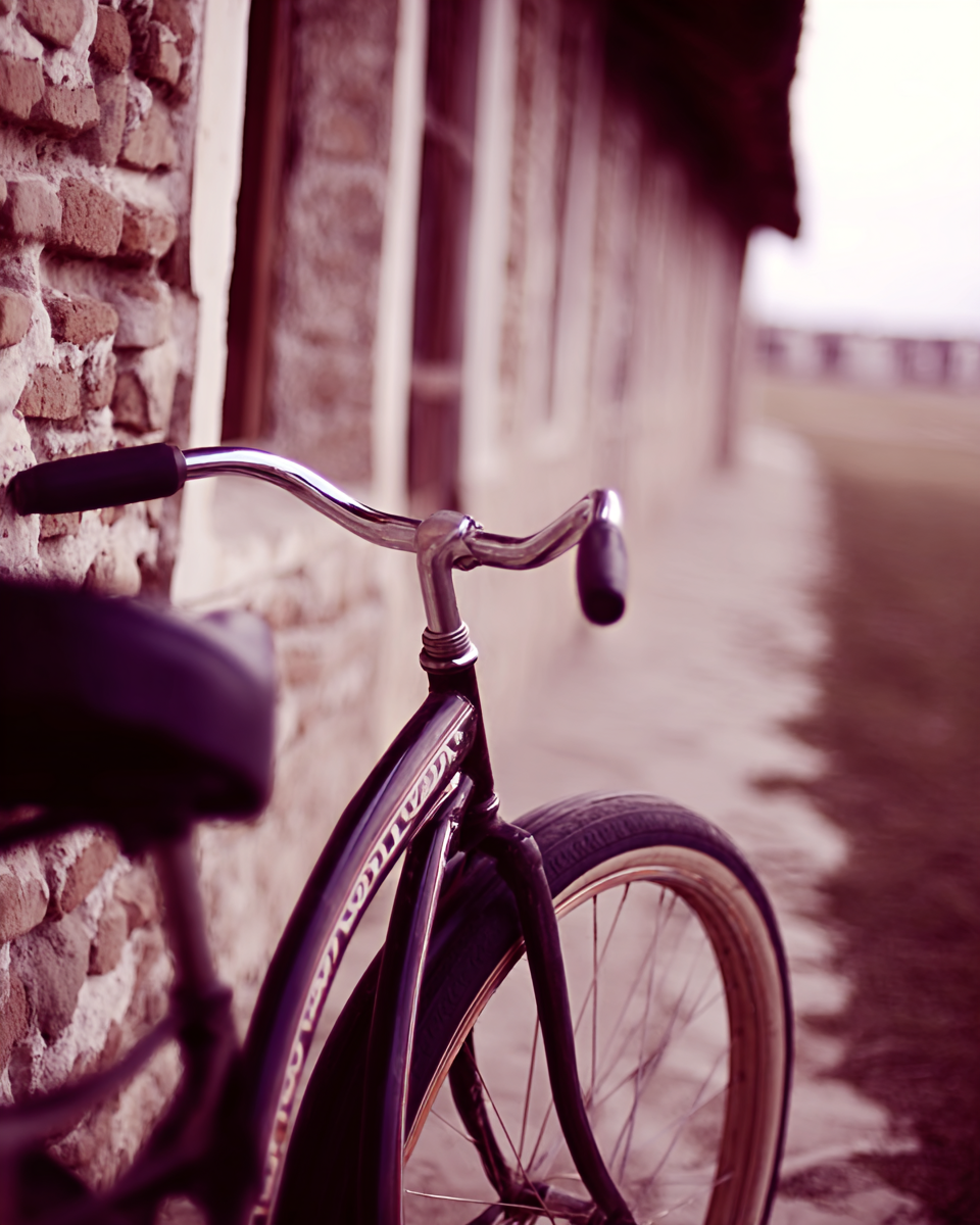 Bicicleta vintage encostada em parede de pedra, com tons rosados e marrons, iluminação suave, textura rústica e perspectiva linear profunda.