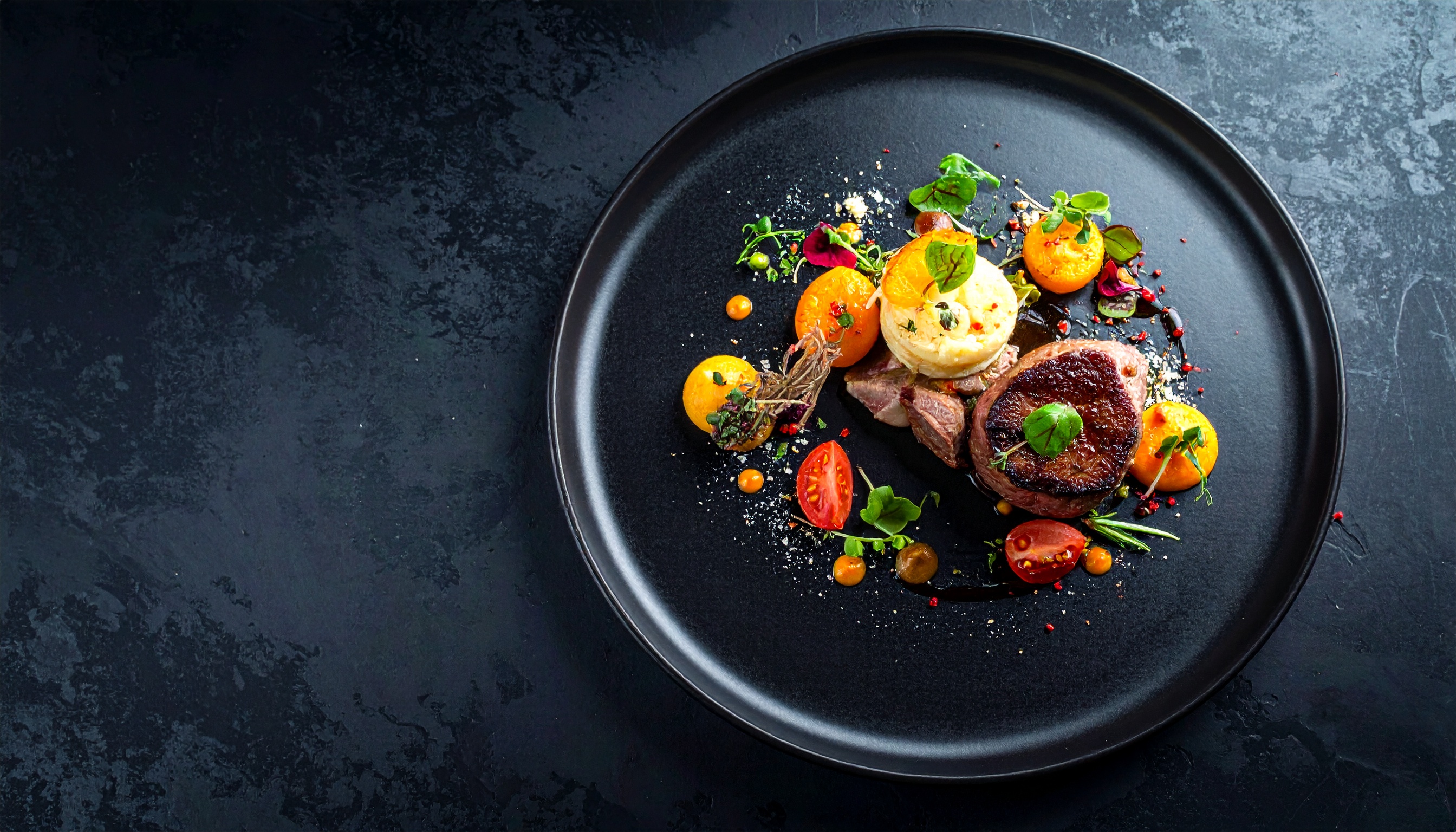 A gourmet dish artfully presented on a sleek black plate