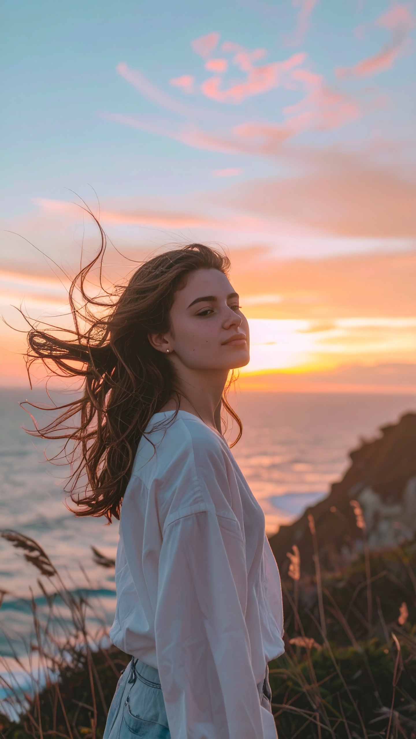 Woman Enjoying Sunset on a Cliff by the Sea