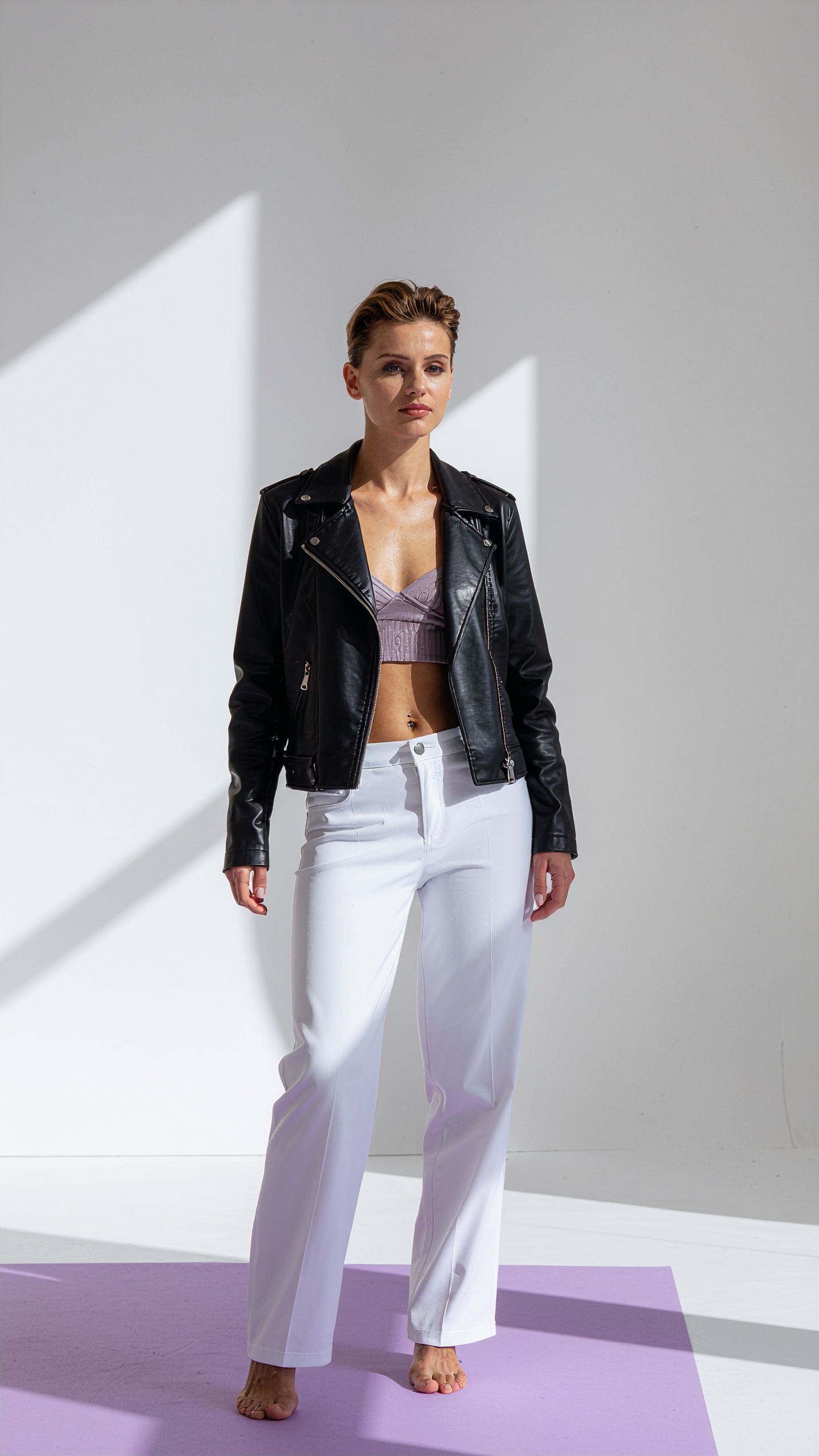 Woman in Minimalist Studio Wearing Black Leather Jacket