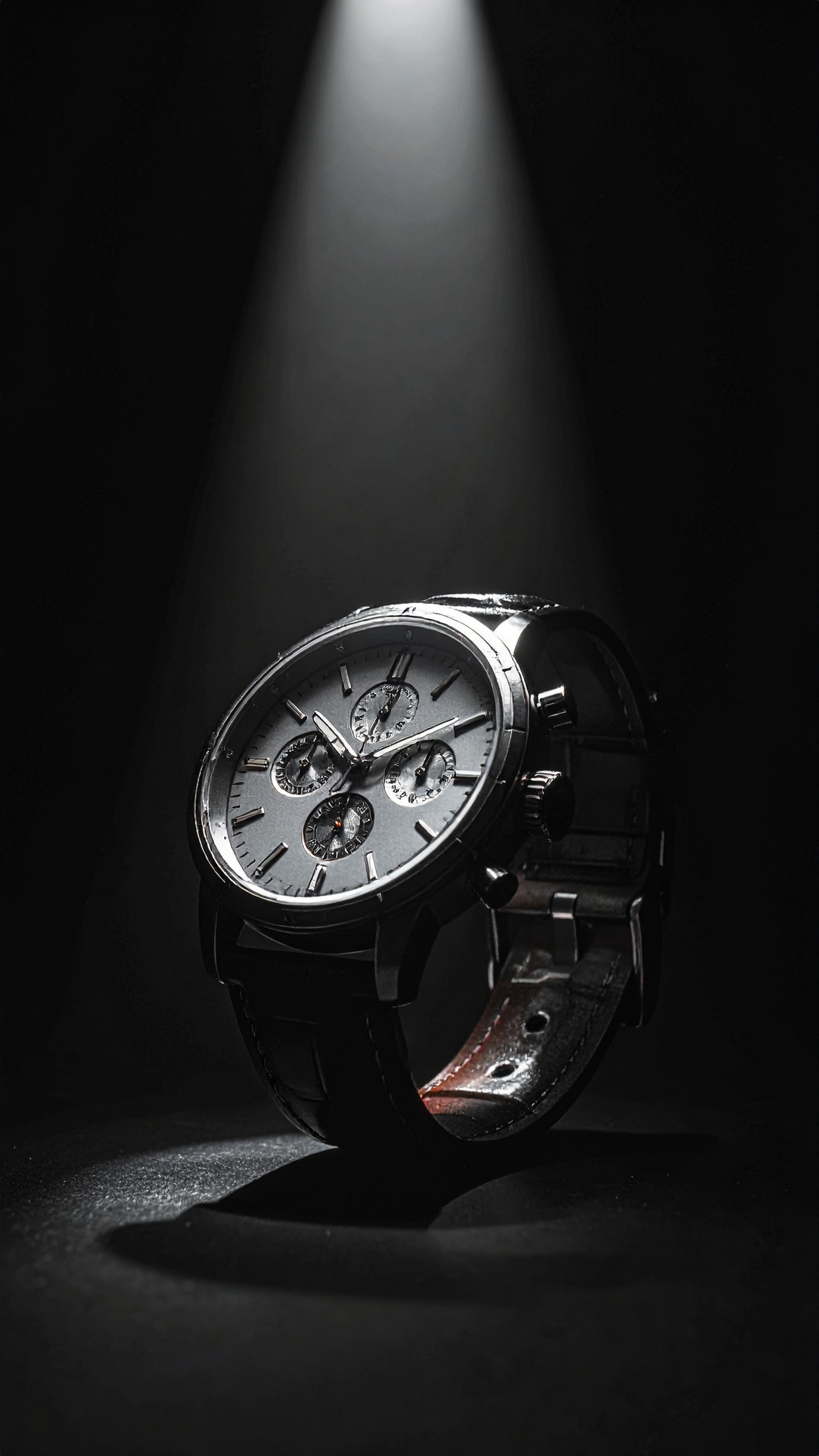 A sophisticated wristwatch is elegantly showcased under a spotlight