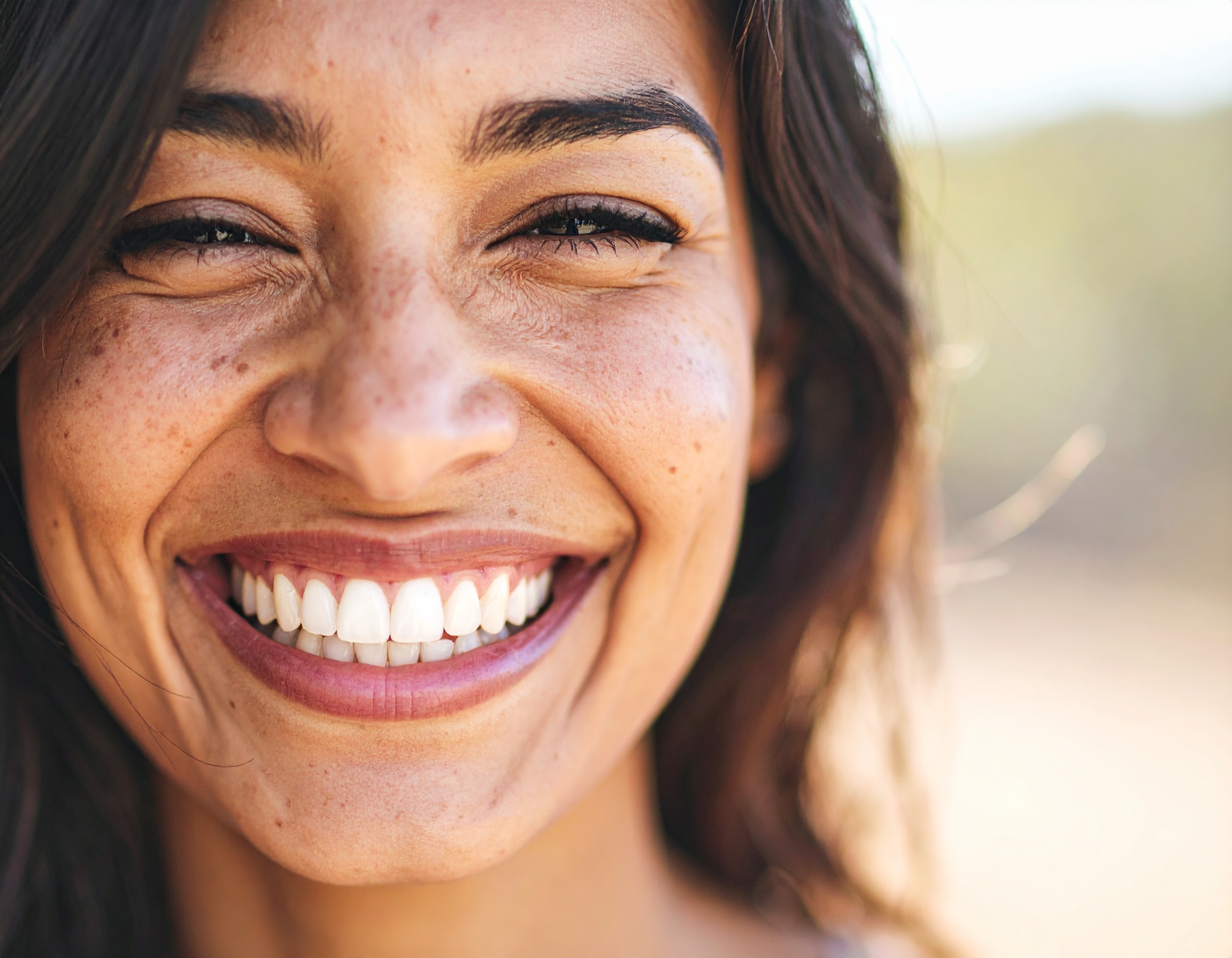 A joyful woman with a bright smile, showcasing her radiant teeth