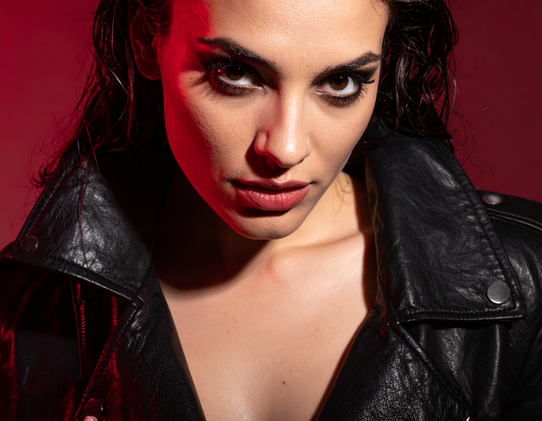 A fierce woman in a black leather jacket with bold makeup