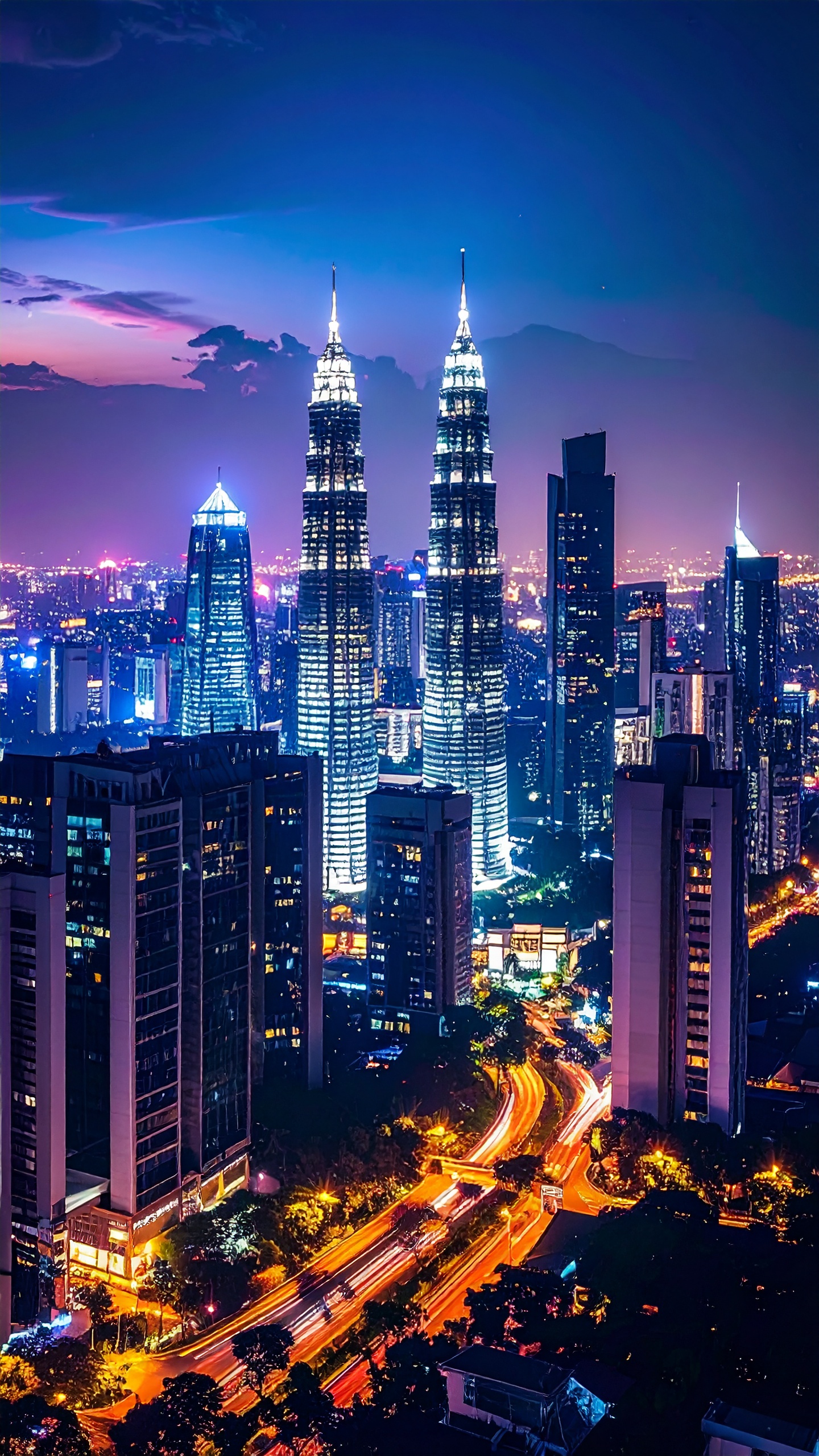 As icônicas Torres Petronas destacam-se na paisagem urbana de Kuala Lumpur ao anoitecer. Elas servem como símbolos de modernidade e avanço arquitetônico na Malásia. A iluminação noturna cria um contraste vibrante com o céu, enquanto as luzes da cidade trazem vida e movimento à cena. Este visual é ideal para transmitir inovação em campanhas publicitárias e turísticas. Além de sua beleza, as torres são um ponto de encontro cultural e empresarial na cidade.