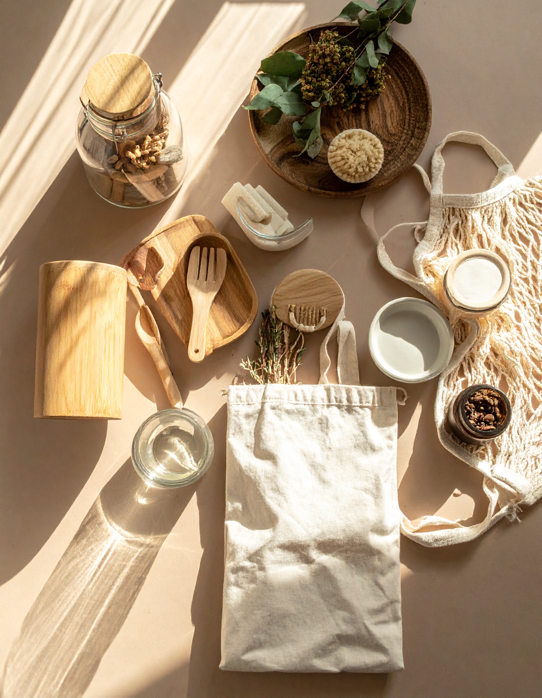 A collection of eco-friendly kitchen items is arranged on a sunlit surface