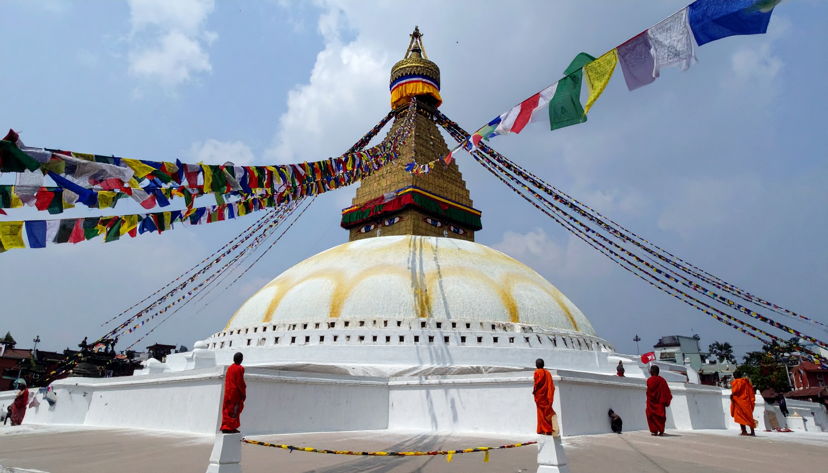 Majestic stupa adorned with colorful prayer flags under a clear sky