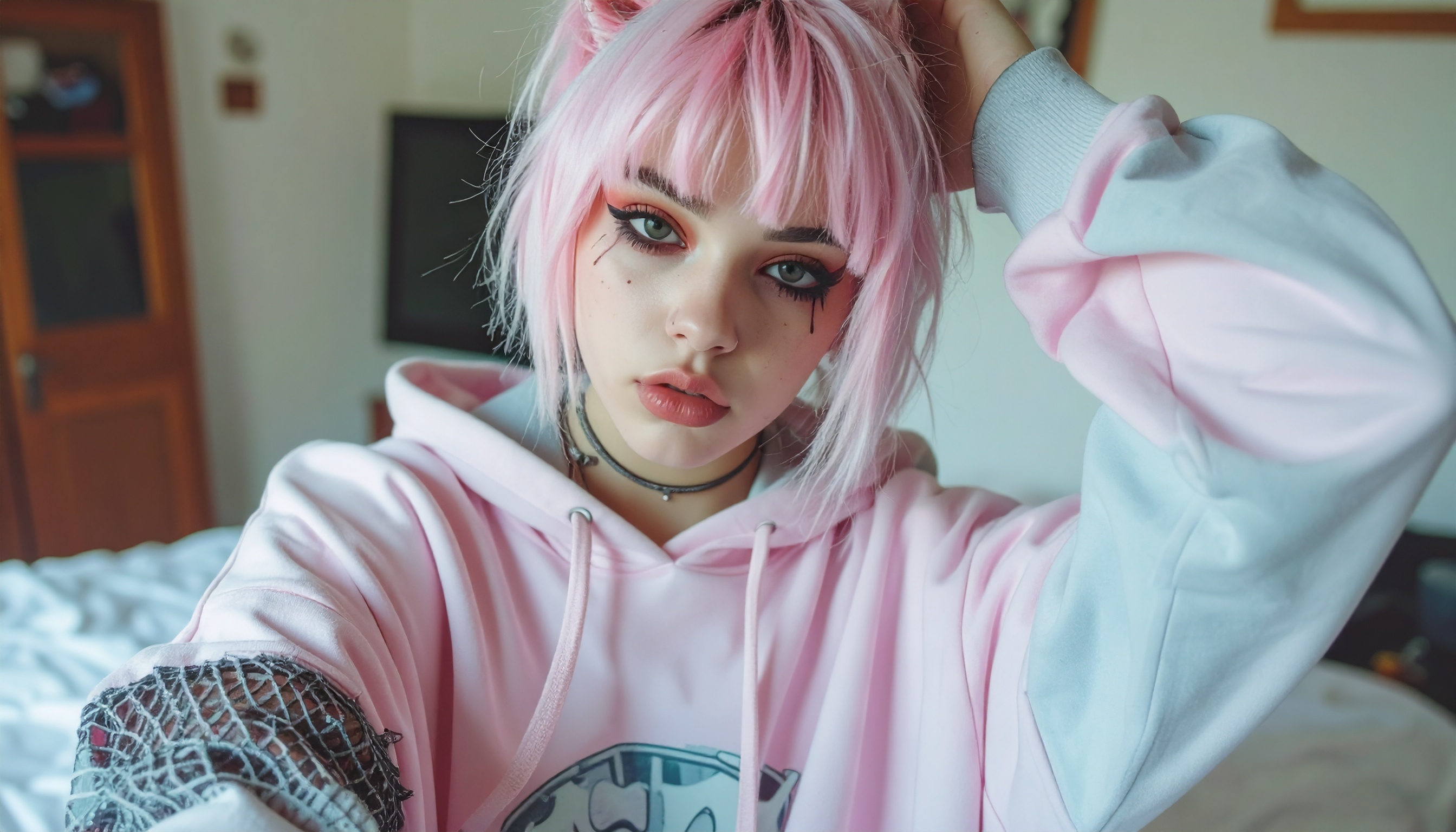 A young person with pink hair and stylish makeup poses in a casual pink hoodie