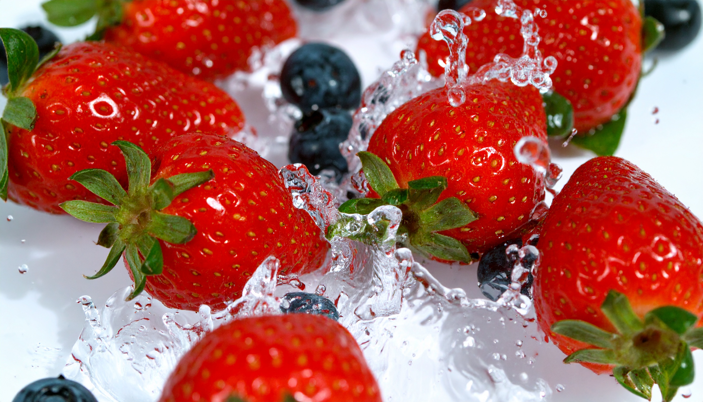 Vibrant Red Strawberries and Blueberries Splashing Water