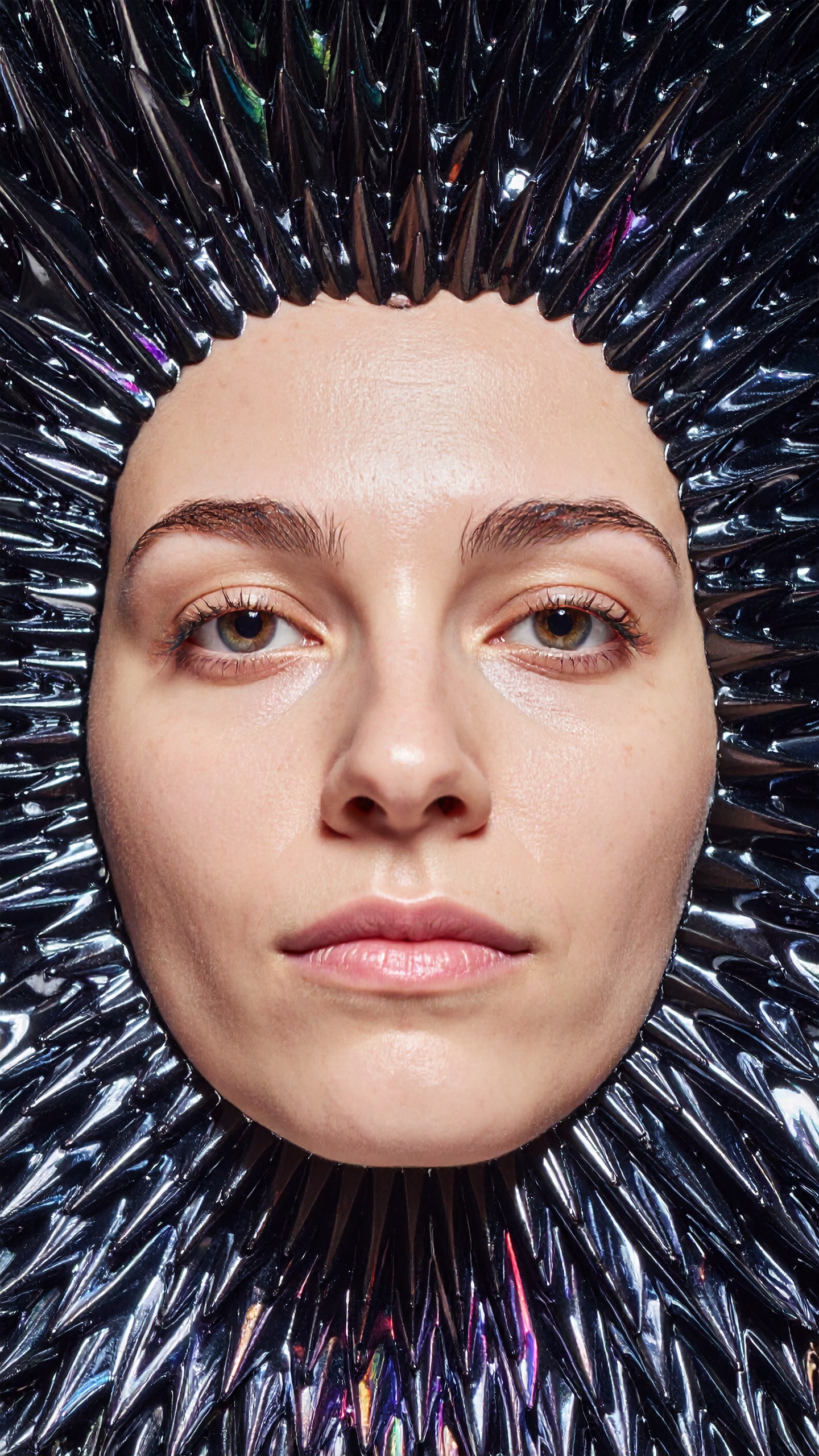 A woman's face framed by a futuristic metallic texture
