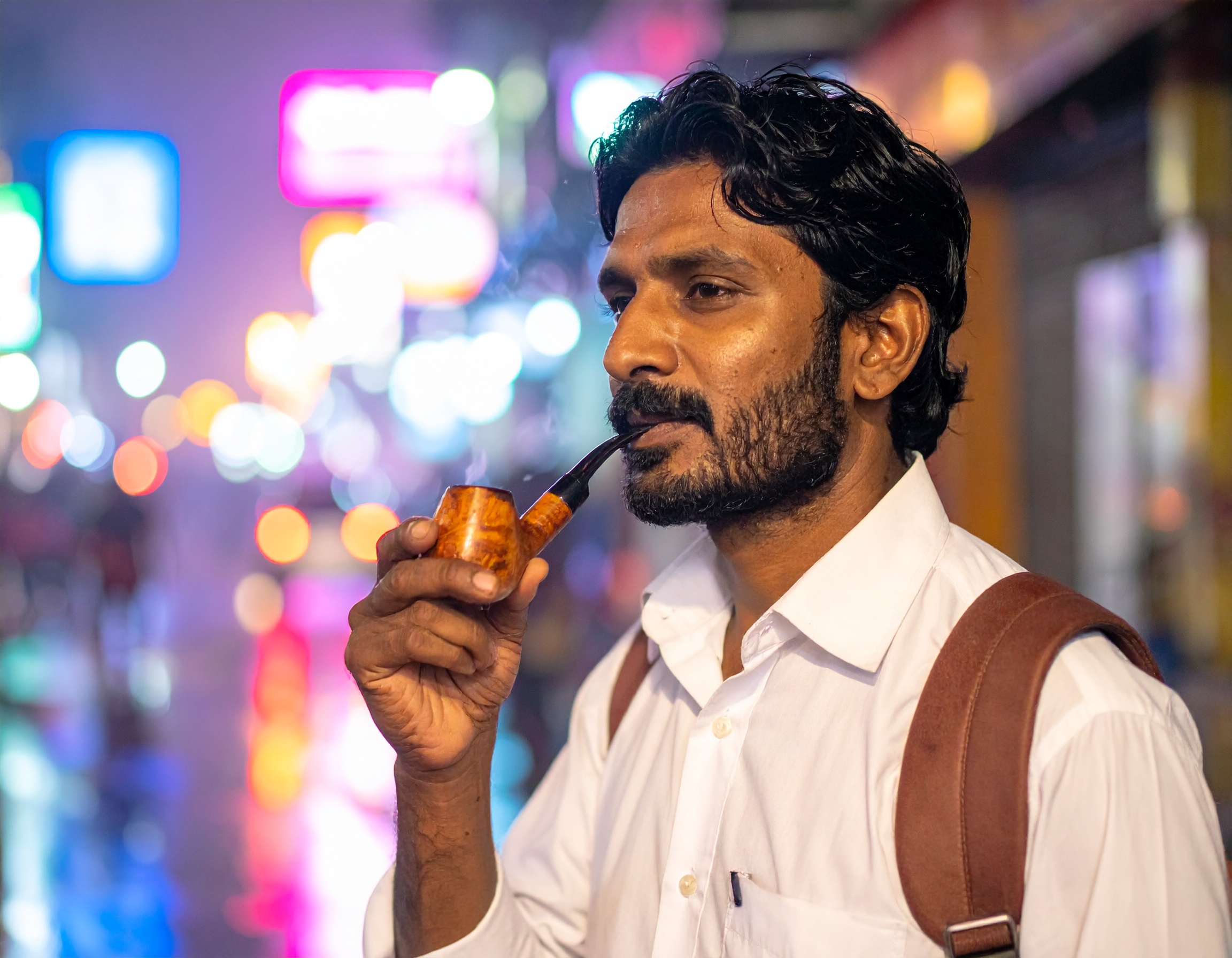 A man enjoys a pipe in a vibrant urban night scene