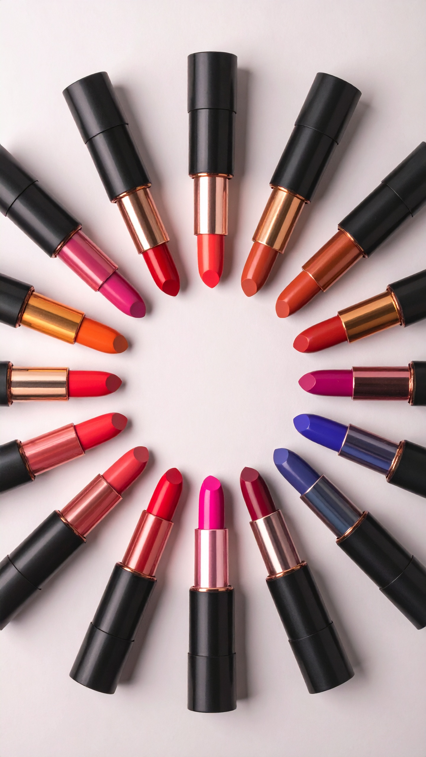 A vibrant array of lipsticks is arranged in a circle on a white background