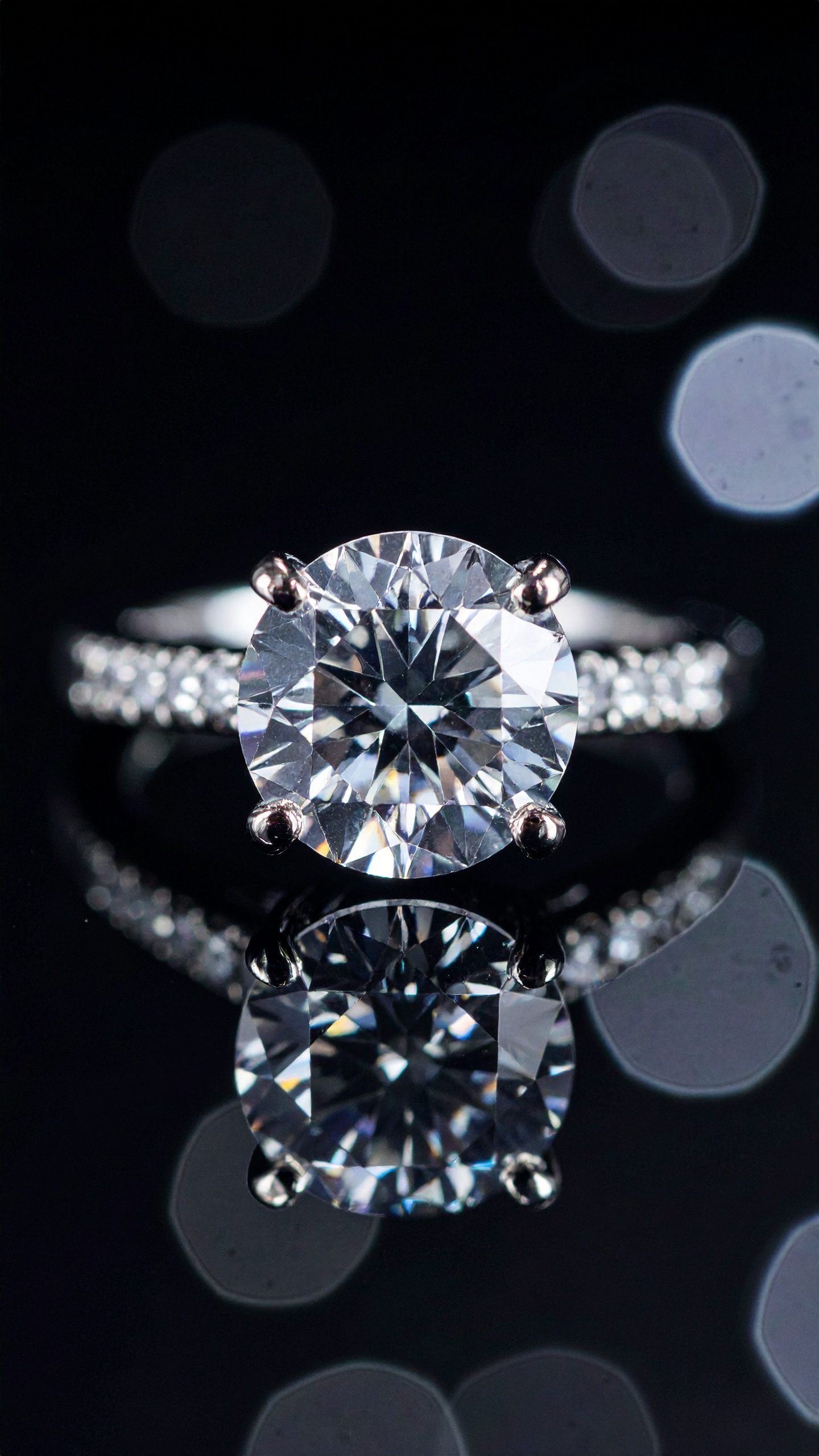 A dazzling diamond ring with a large central stone and pavé band sparkles against a