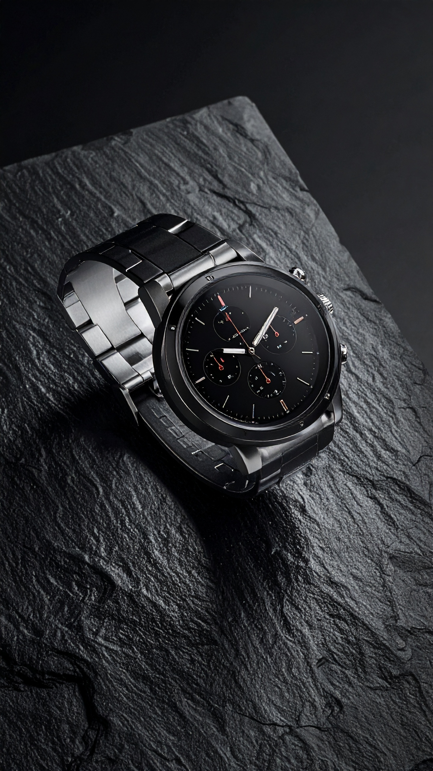 Sleek black metal watch with a sophisticated design on dark slate