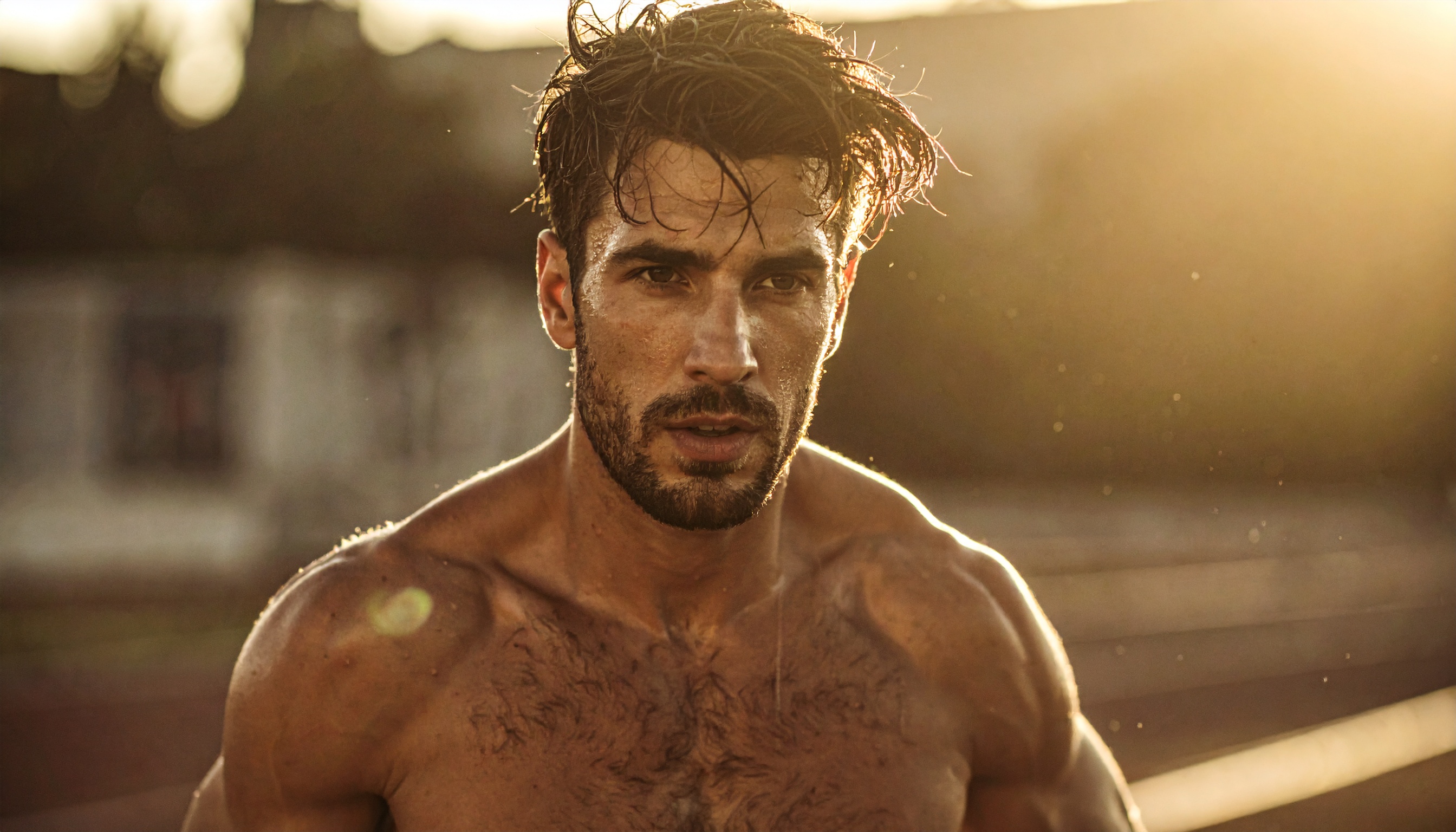 A focused male athlete running outdoors at sunset