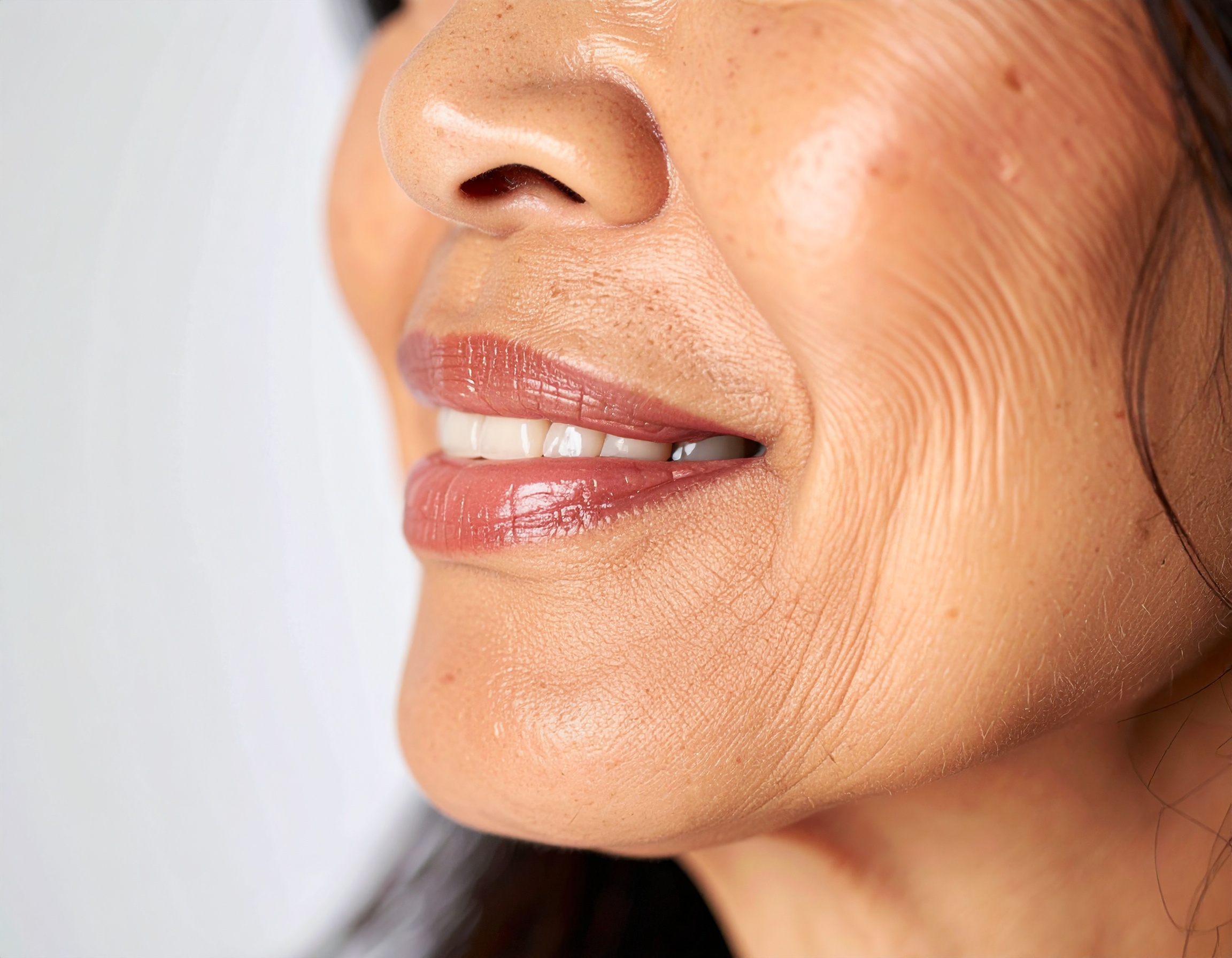 Close-up of a mature woman's smiling lips and smooth skin