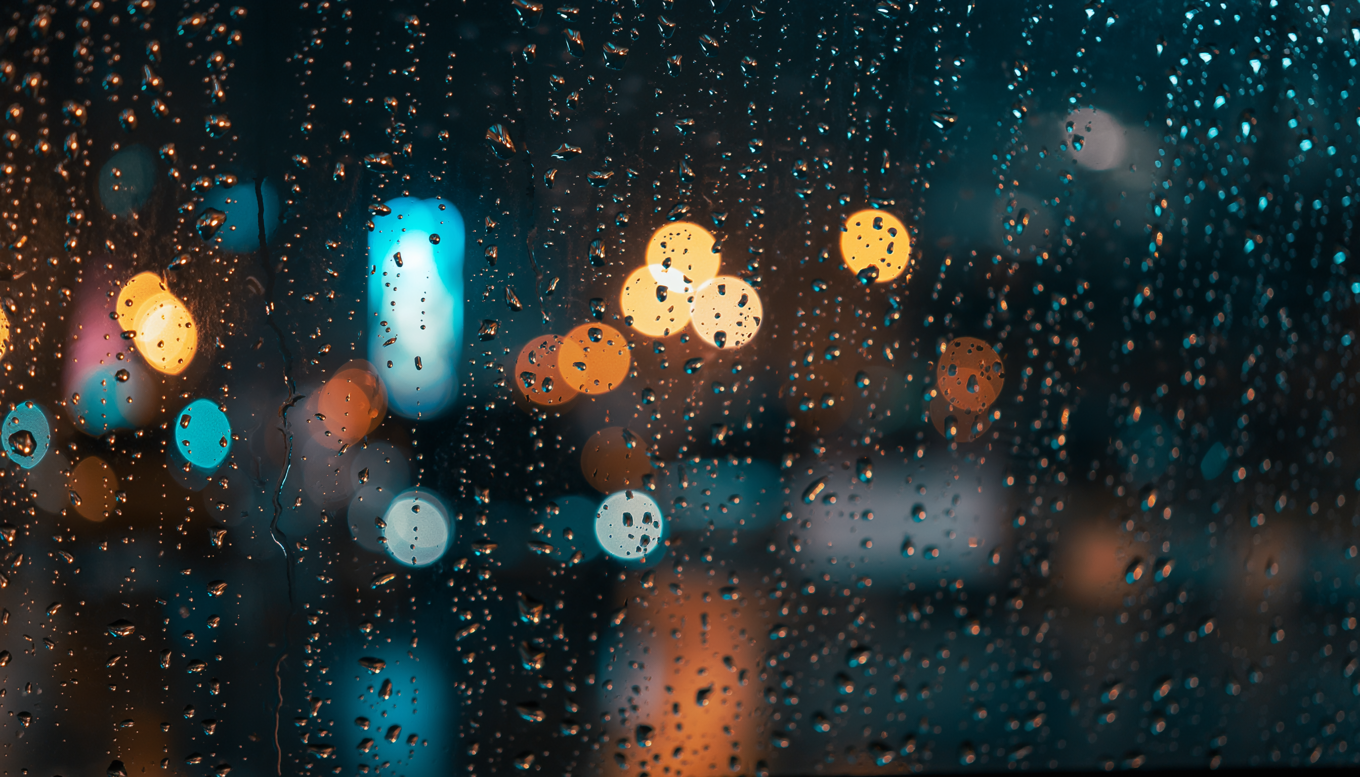 Nighttime Rain Drops on Window with Urban Bokeh Lights