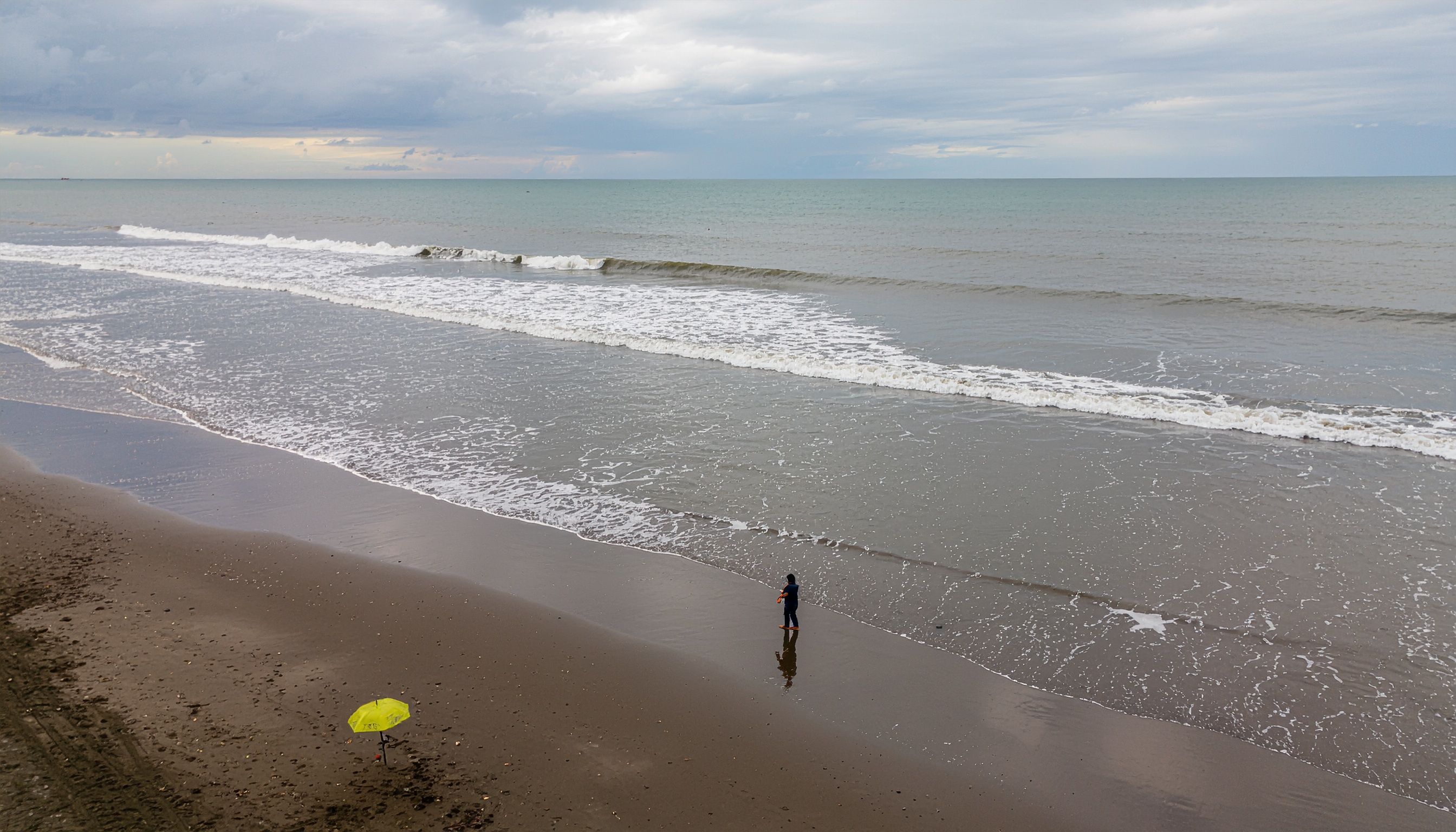 A serene beach scene features gentle waves lapping against the shore