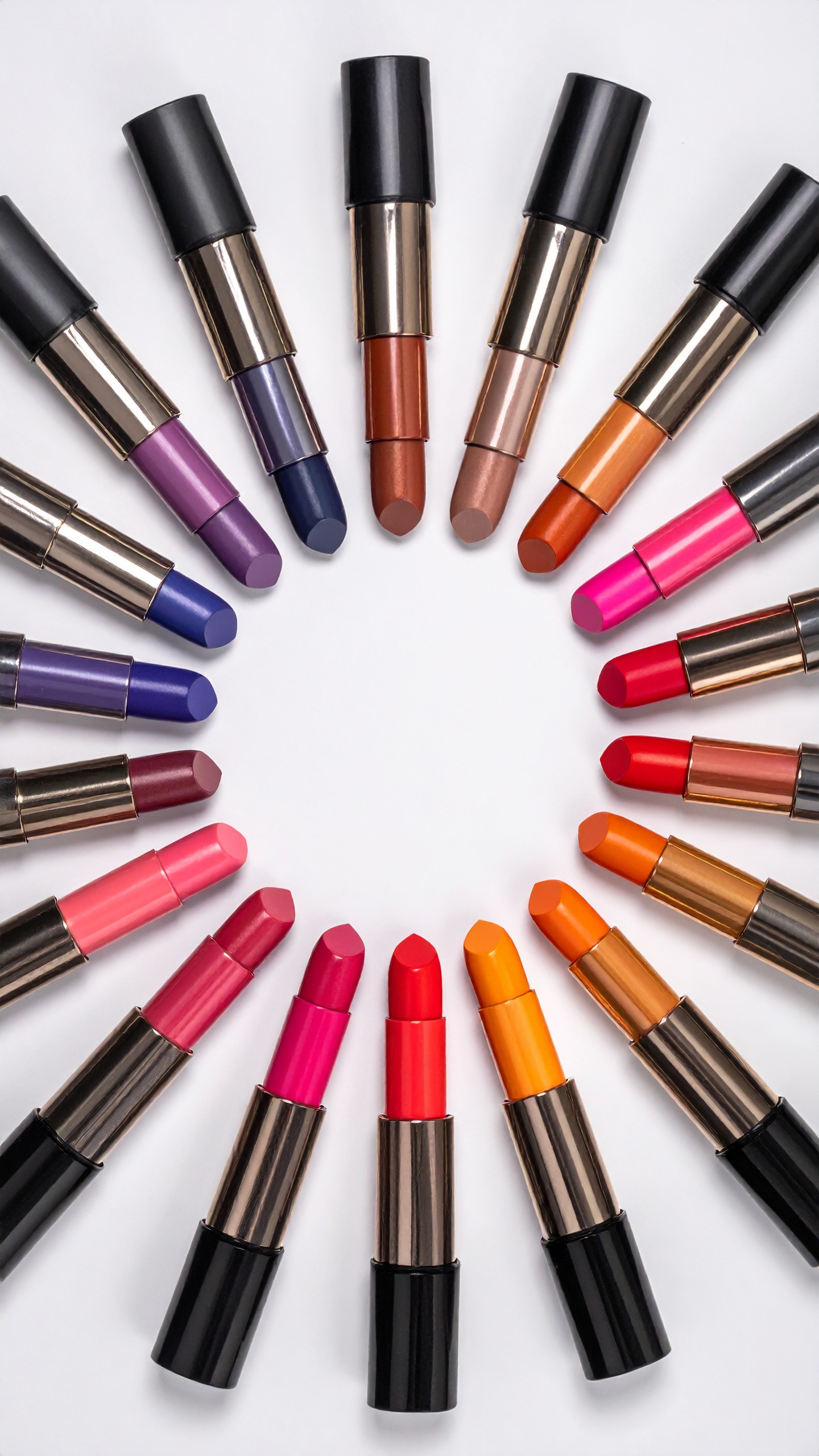 A vibrant array of lipsticks arranged in a semicircle on a white background