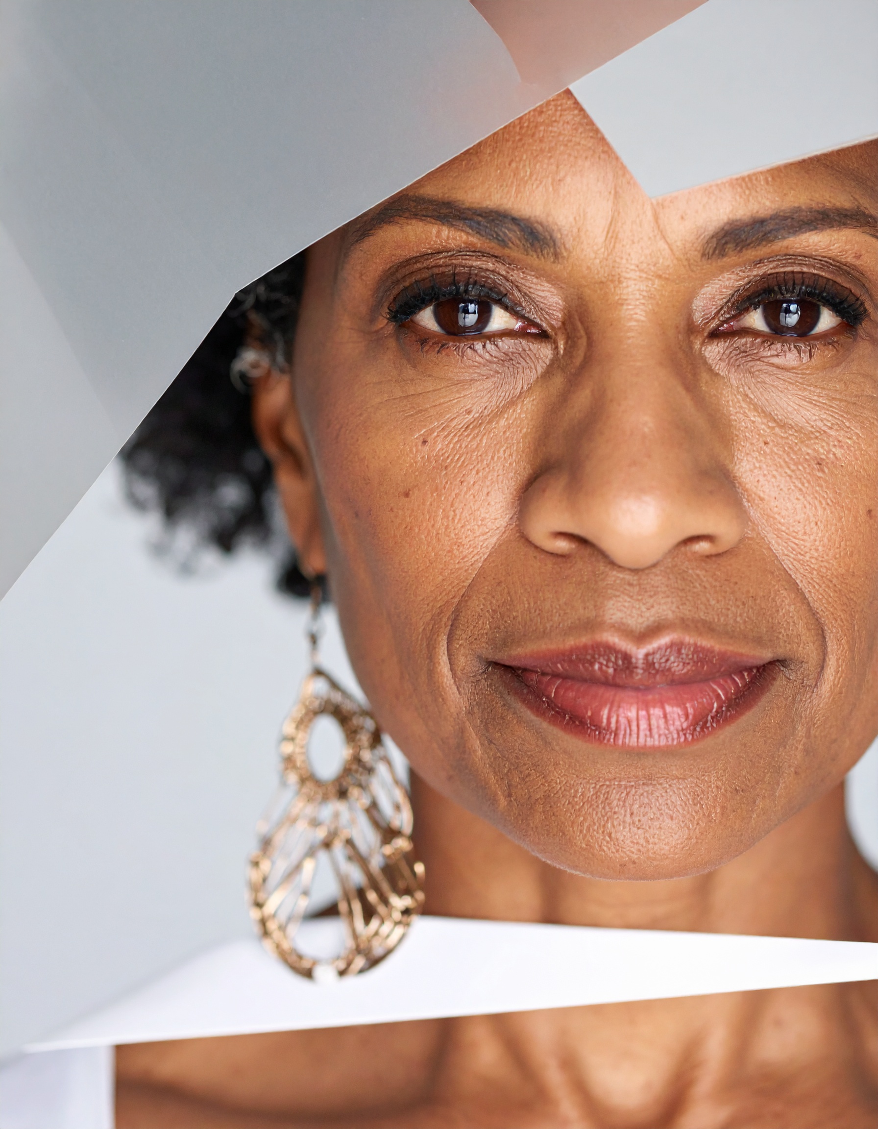 Close-up portrait of a woman wearing ornate earrings with a modern geometric background