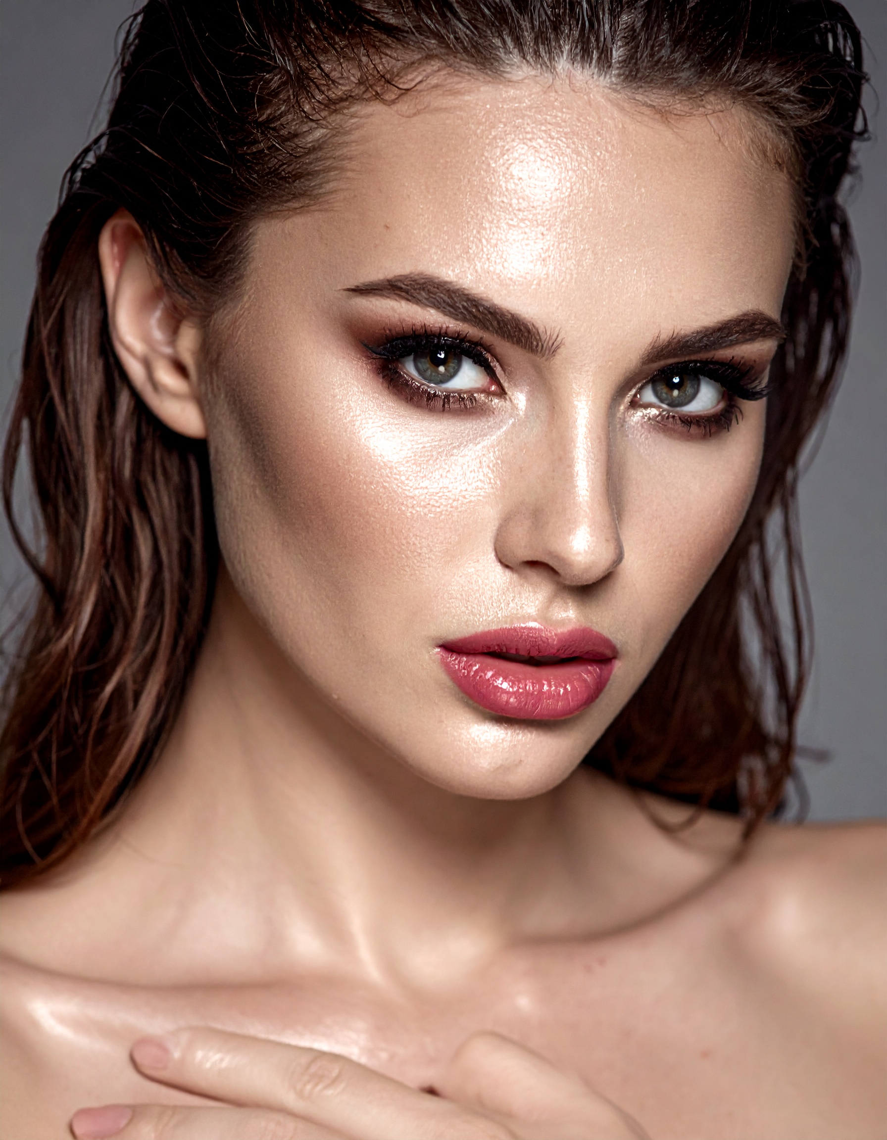 A woman with flawless makeup showcases a glowing complexion and defined features