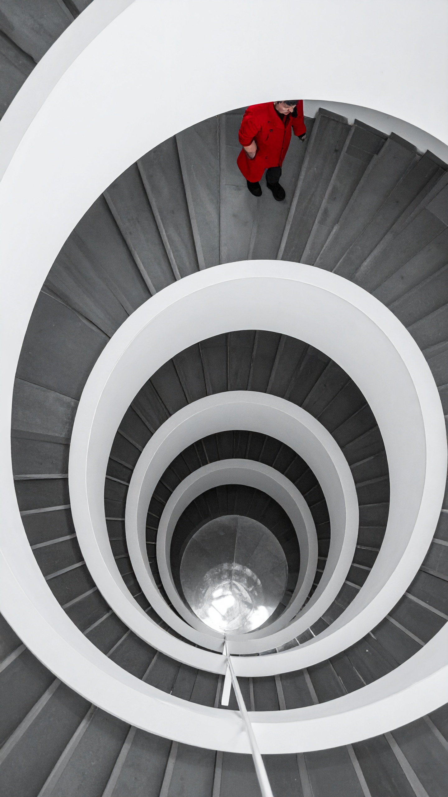 Spiral staircase with a person in a red coat ascending