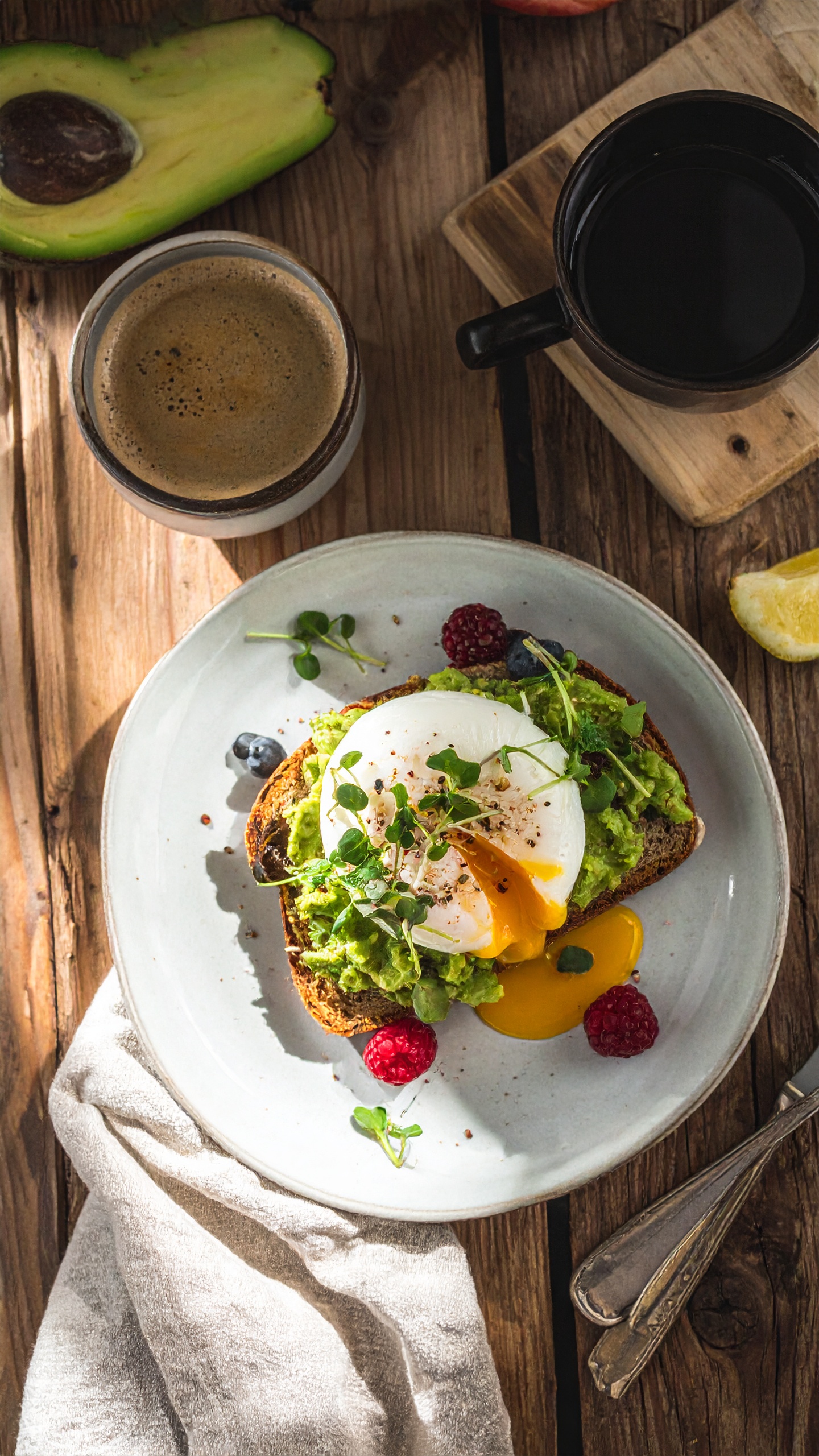 A delicious breakfast spread features avocado toast with a perfectly poached egg