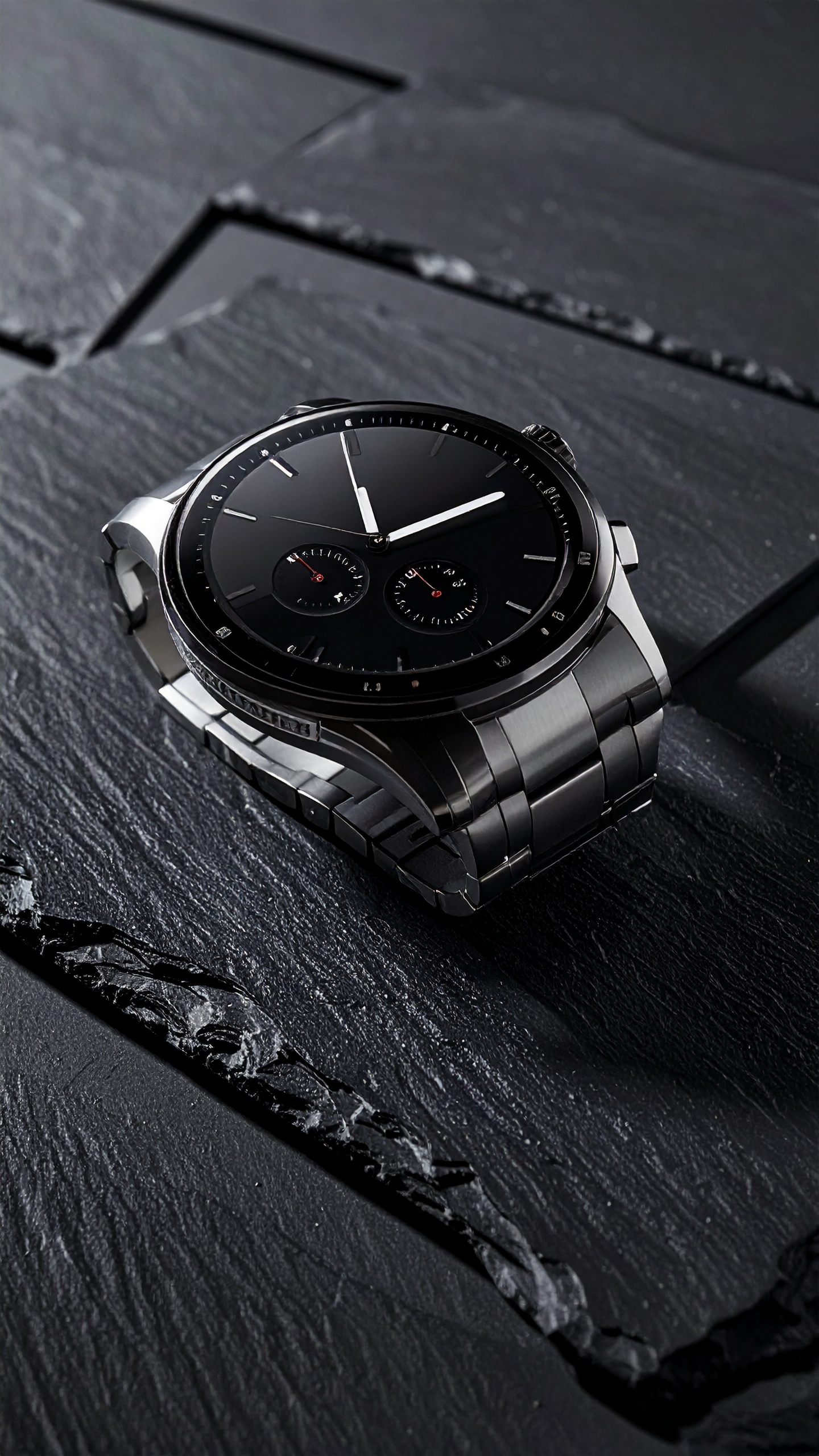 Sleek black wristwatch resting on textured dark slate