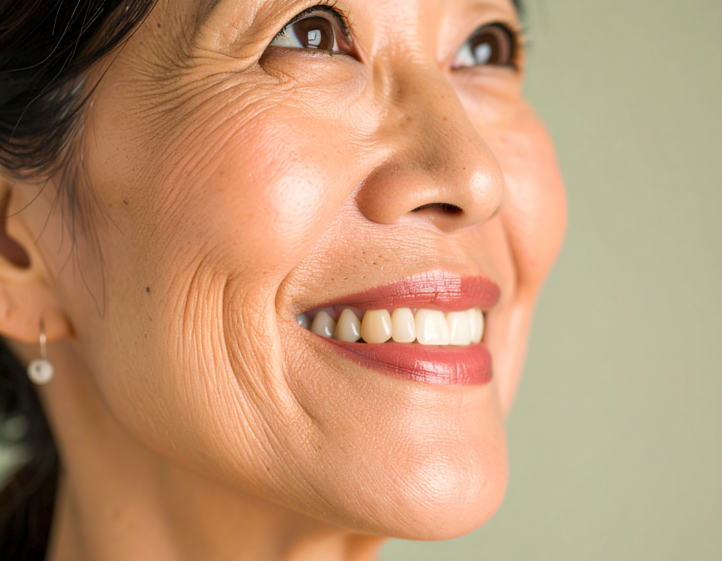 A smiling woman with radiant skin highlights a sense of happiness and confidence