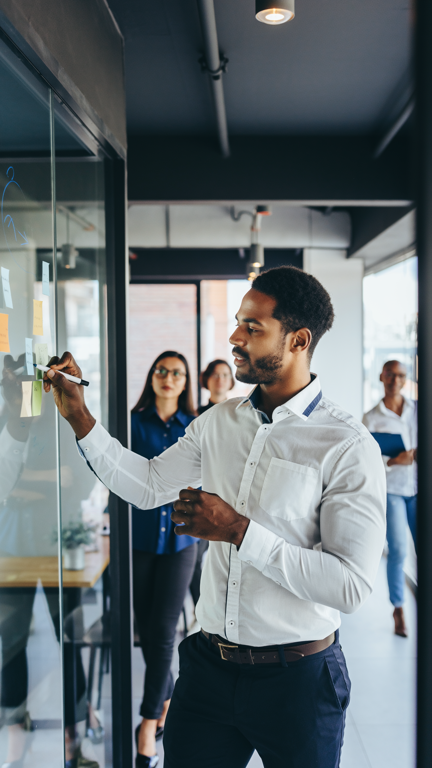 Man Analyzing Sticky Notes in Modern Office