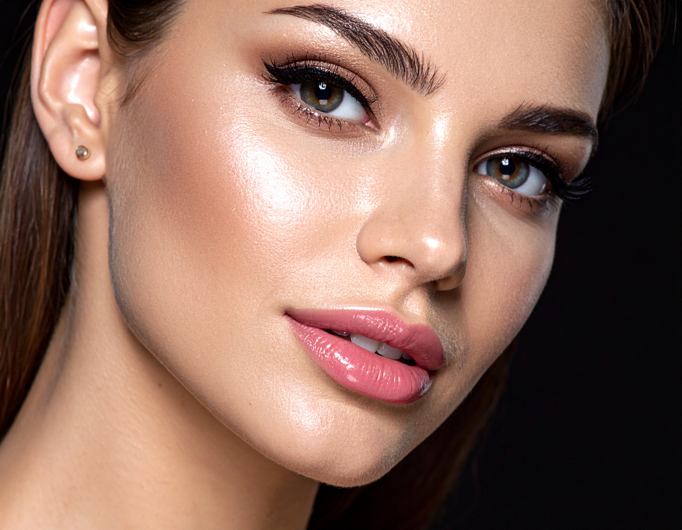 A flawless close-up portrait showcases a woman with radiant skin, enhanced by makeup
