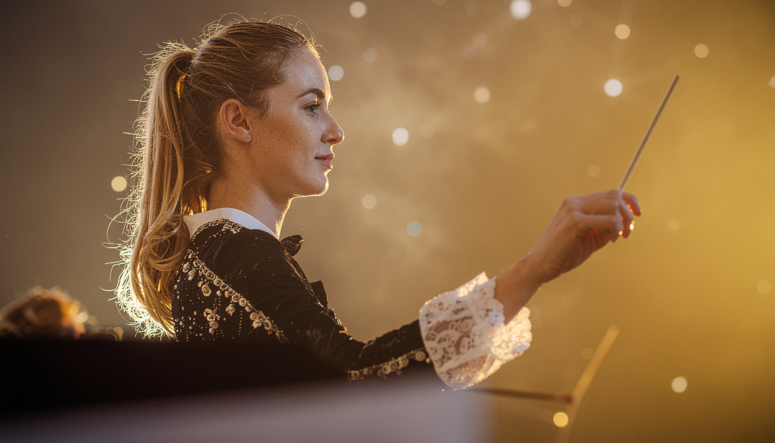 Conductor Leading Orchestra with Focused Expression