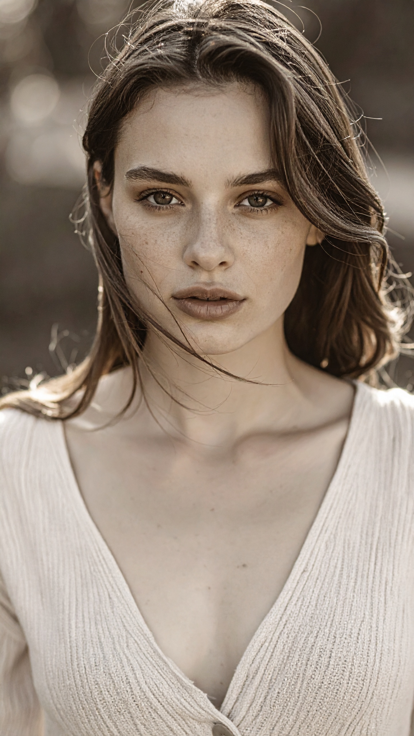 A woman with natural makeup looks directly at the camera, embodying a serene expression
