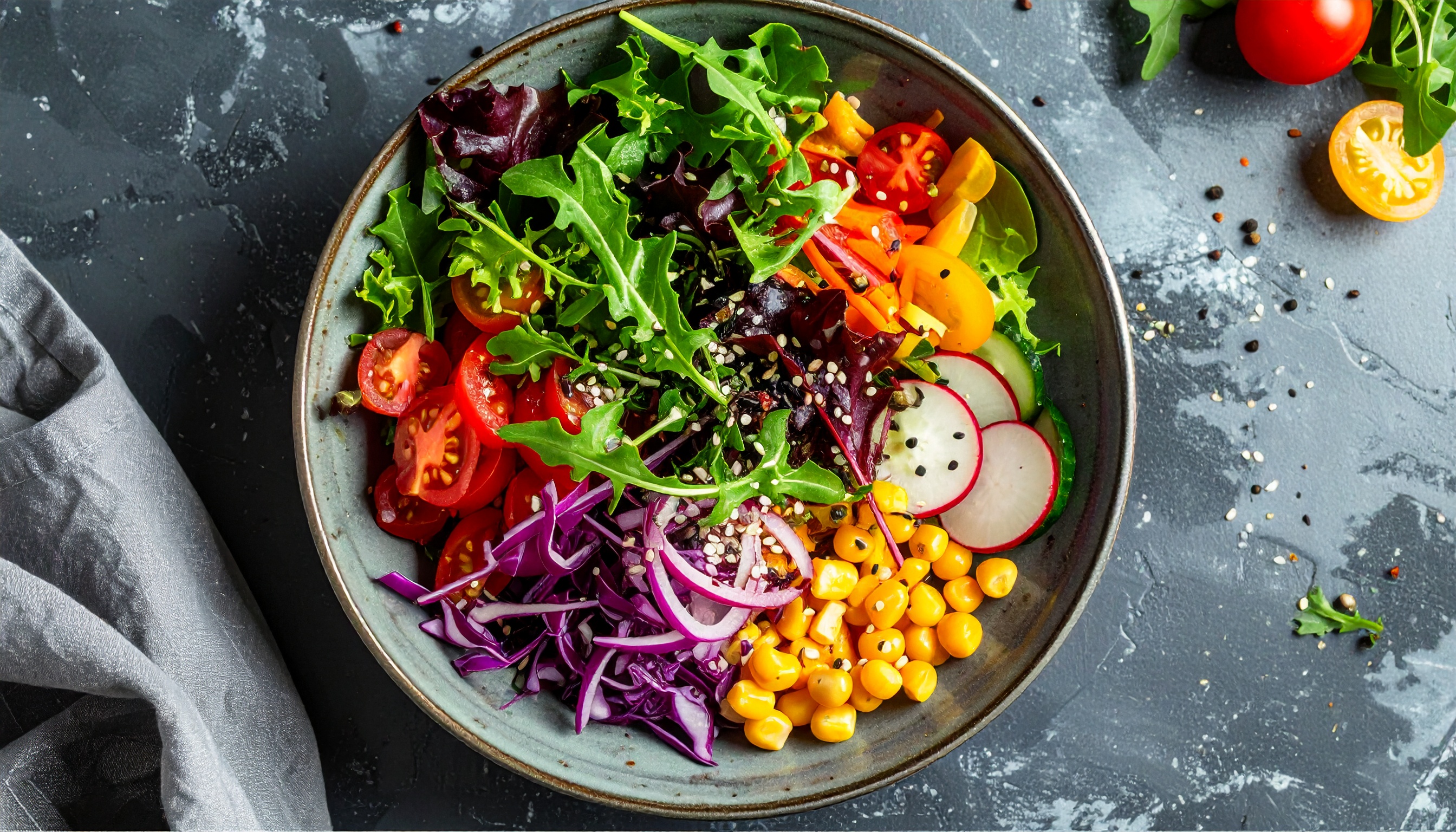 Salada vibrante e colorida com folhas verdes frescas, tomates, rabanetes, milho e repolho roxo, apresentada em um prato rústico com fundo texturizado, ideal para inspiração em alimentação saudável e vegana.