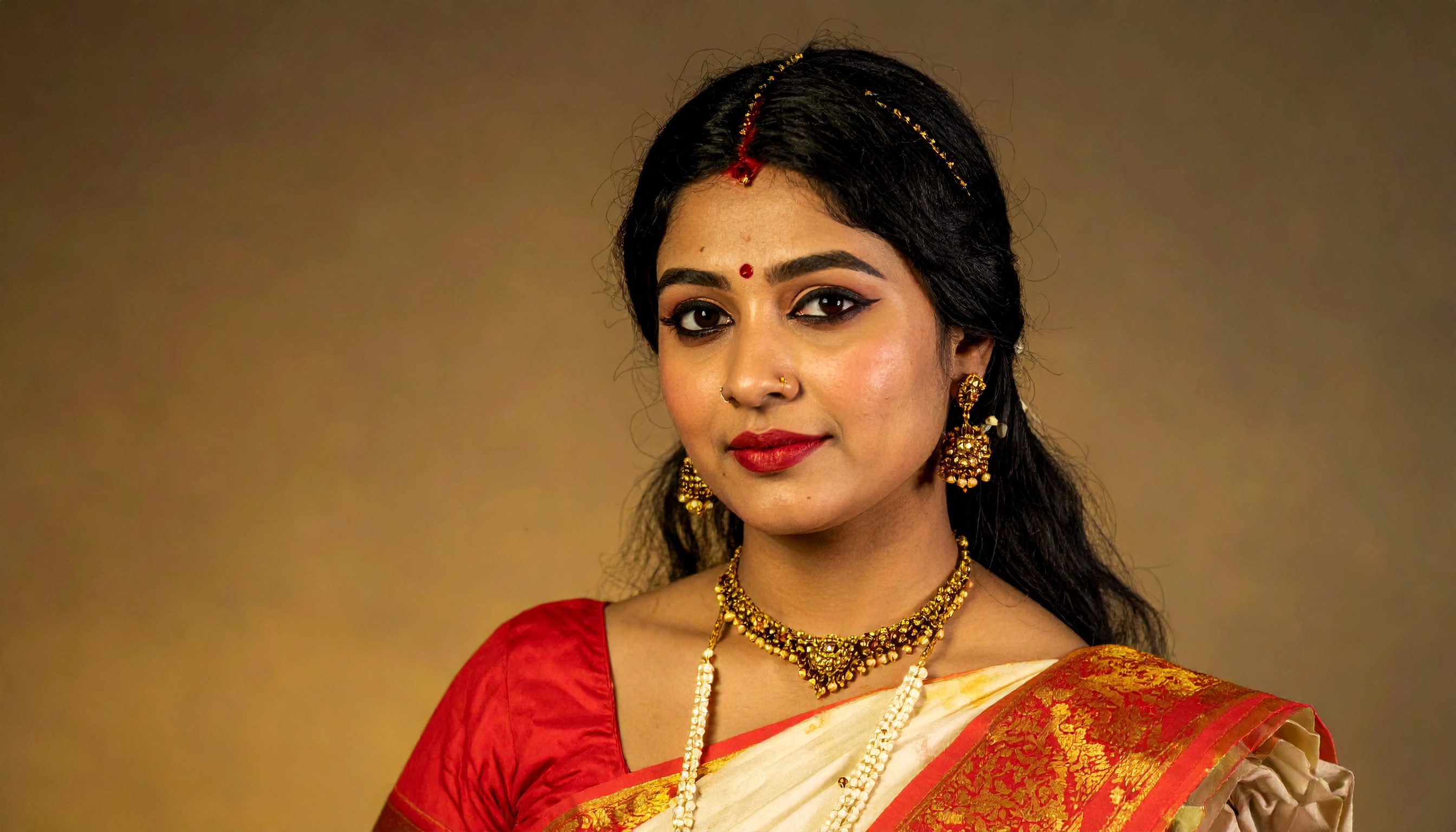 A woman adorned in traditional Indian attire with intricate jewelry