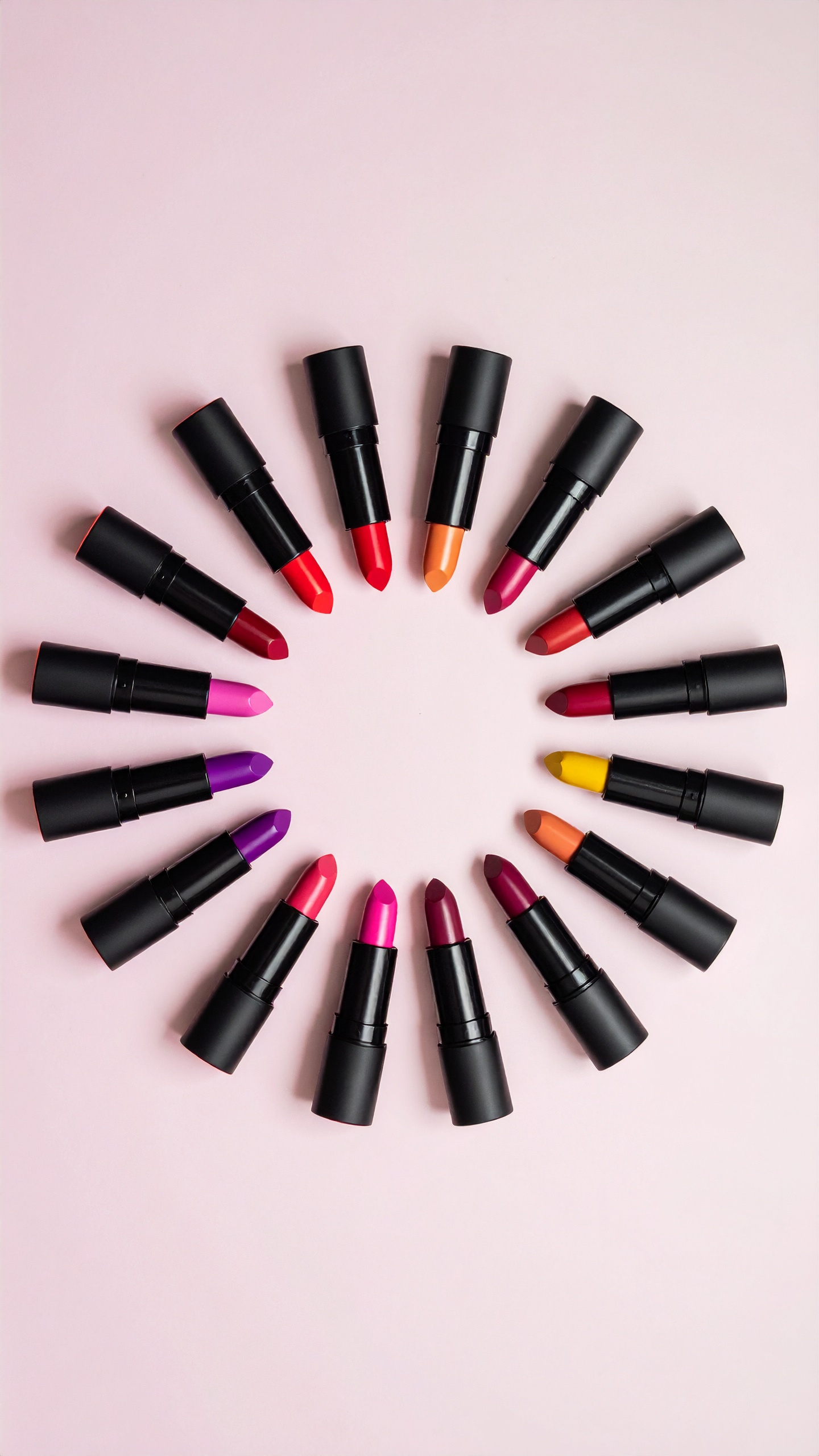 A vibrant array of lipsticks arranged in a circular pattern captivates the eye