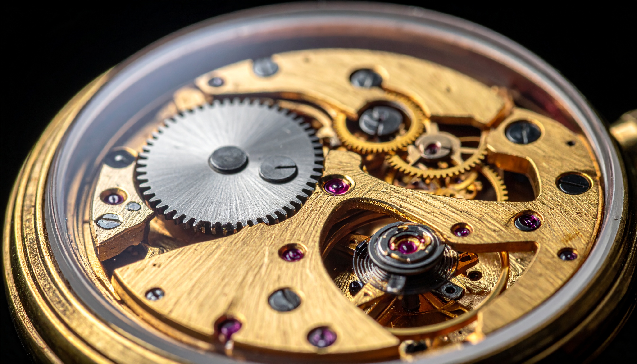 Mecanismo de relógio em ouro com engrenagens intrincadas. Ideal para amantes de relojoaria fina e colecionadores exigentes. O design revela detalhes minuciosos dos componentes, com pedras vermelhas que contrastam com o dourado. Perfeito para uso em ocasiões formais, destacando-se como peça de luxo. A precisão e a beleza tornam-no uma obra-prima atemporal.