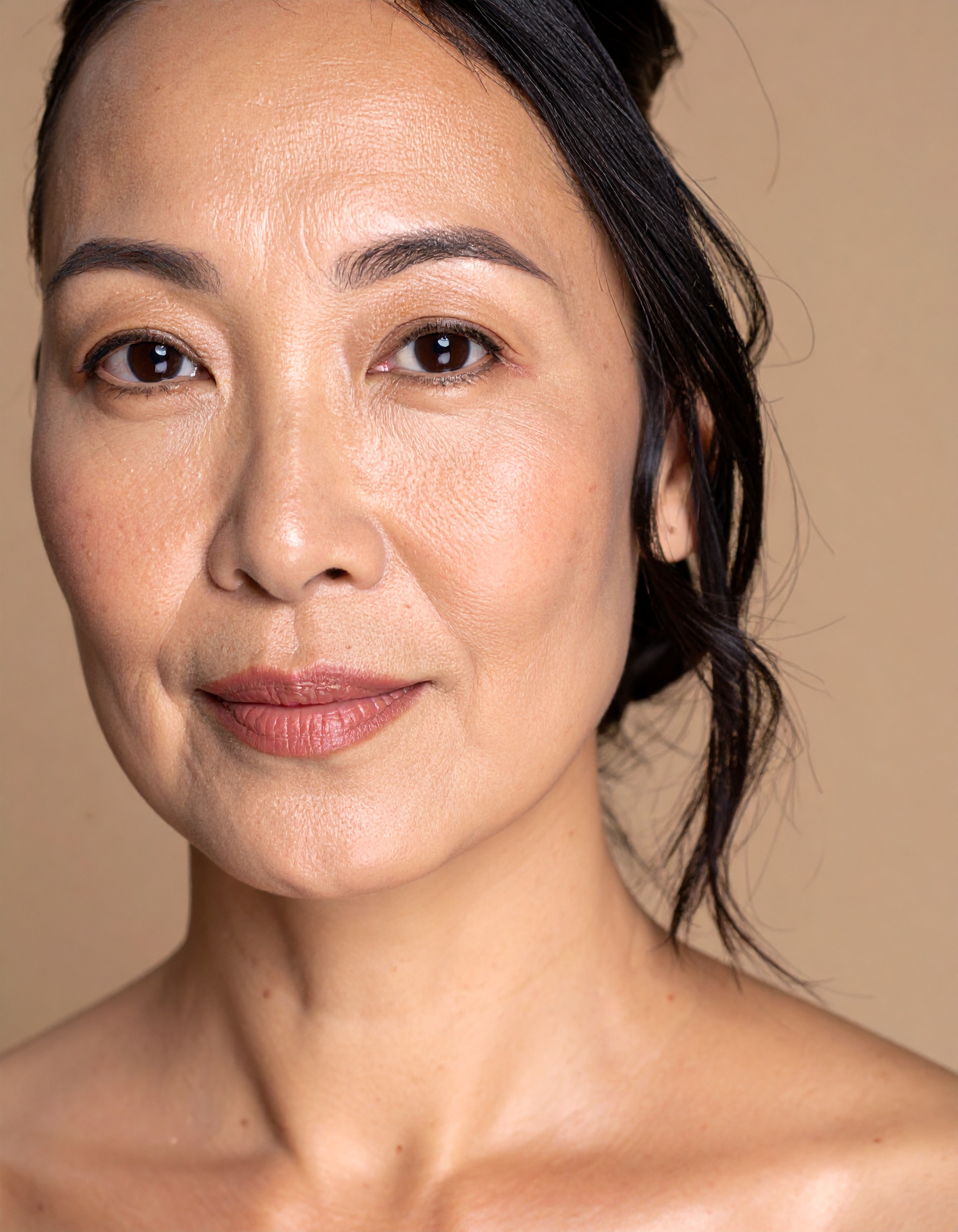 A close-up portrait of a confident woman against a neutral background