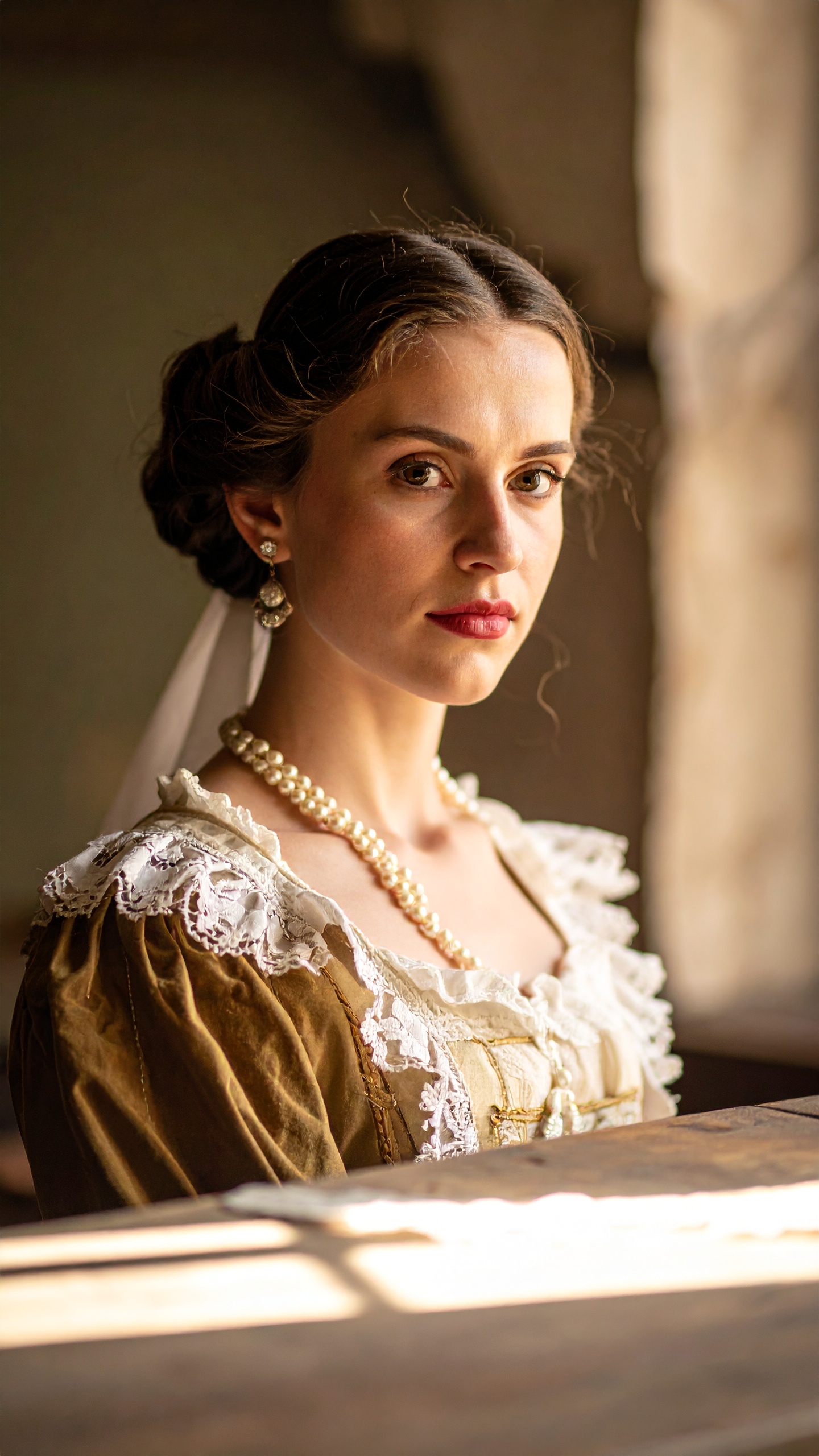 A woman in a vintage dress with lace details gazes thoughtfully