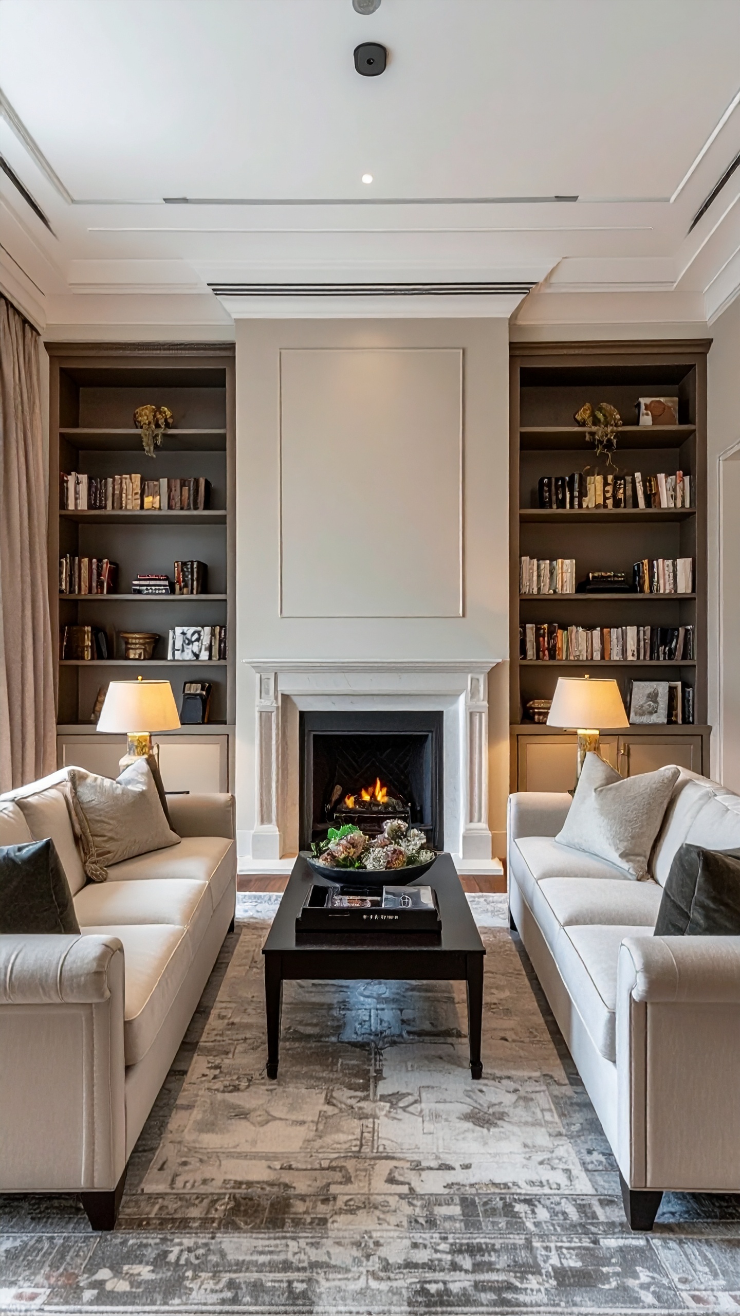 Elegant living room features a cozy fireplace and built-in bookshelves