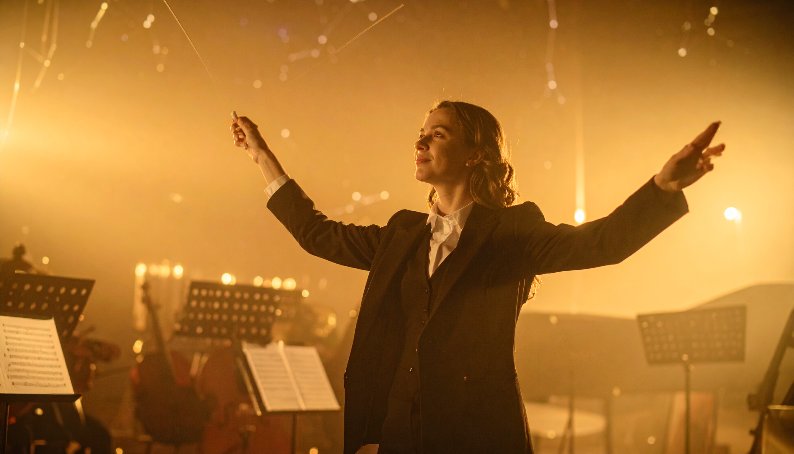 Conductor Leading Orchestra Under Golden Lighting
