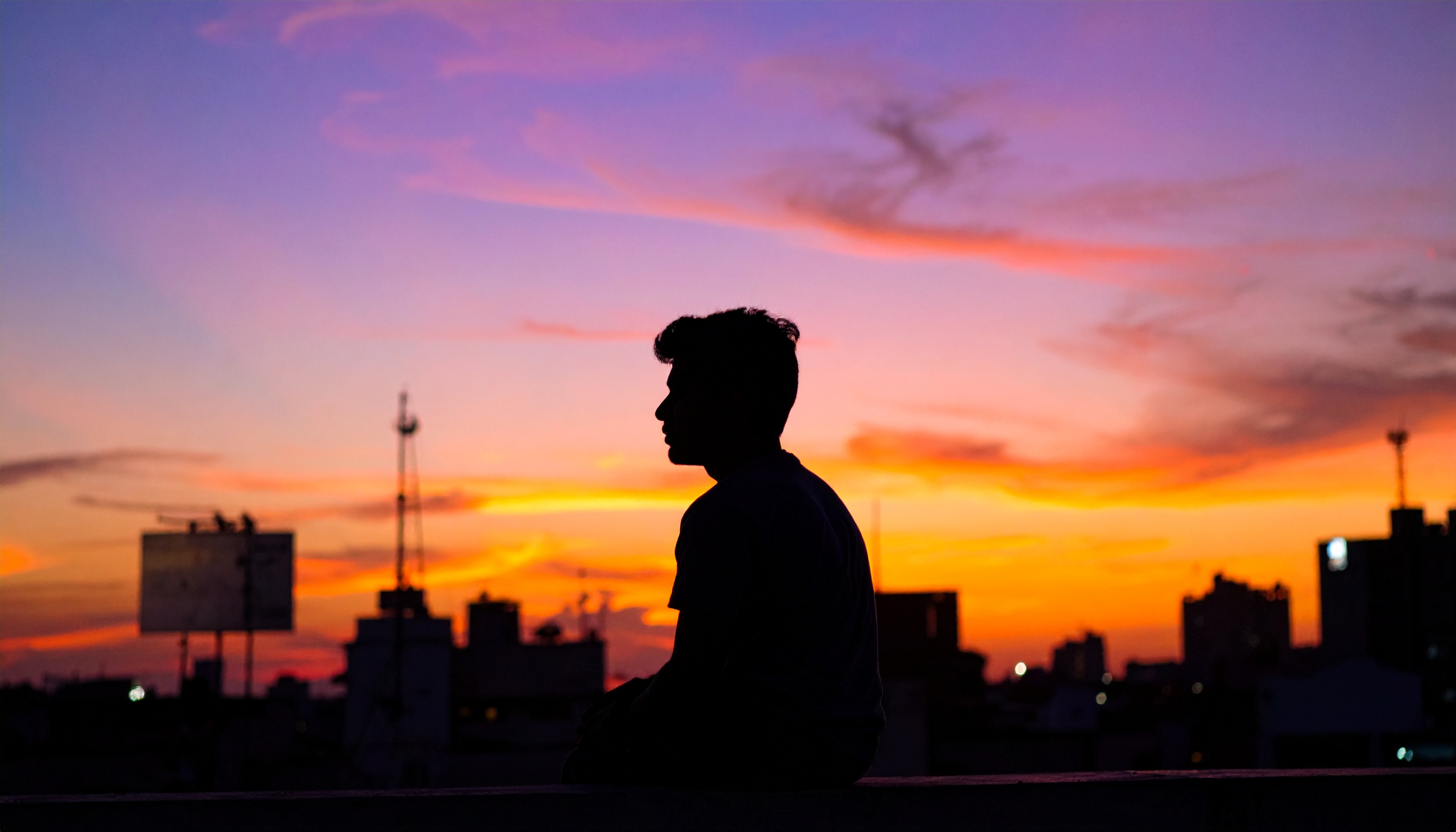 Silhouette of a person against a vibrant sunset skyline