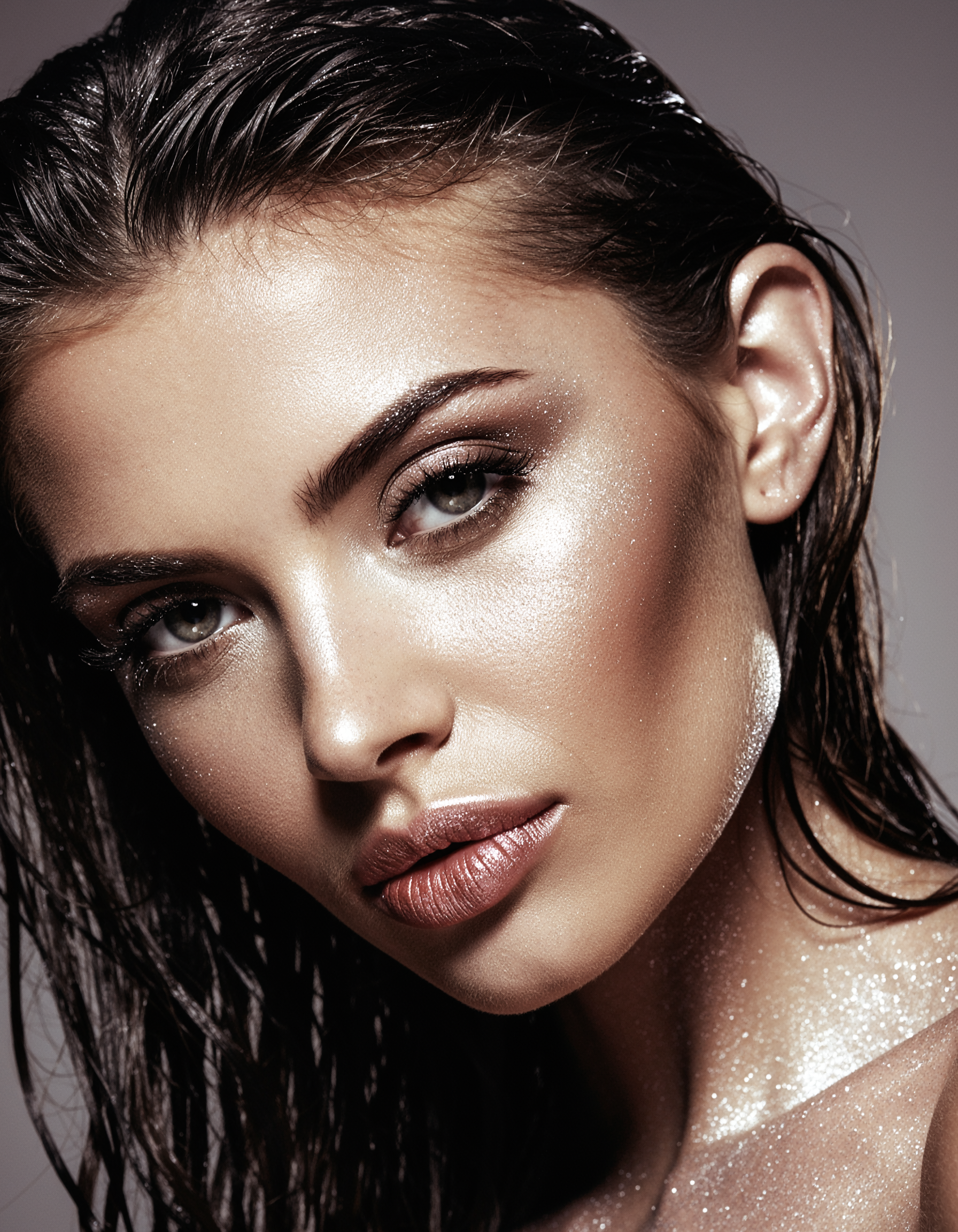A stunning portrait of a woman with shimmering makeup and wet hair