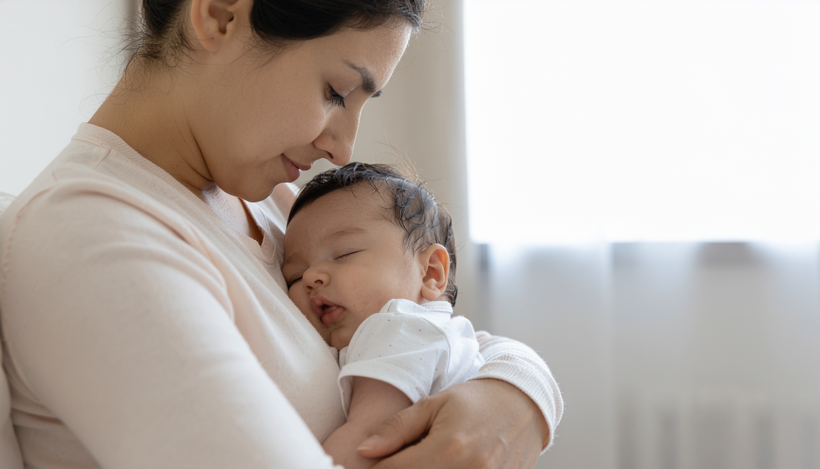 Woman Holding Sleeping Baby in Gentle Light
