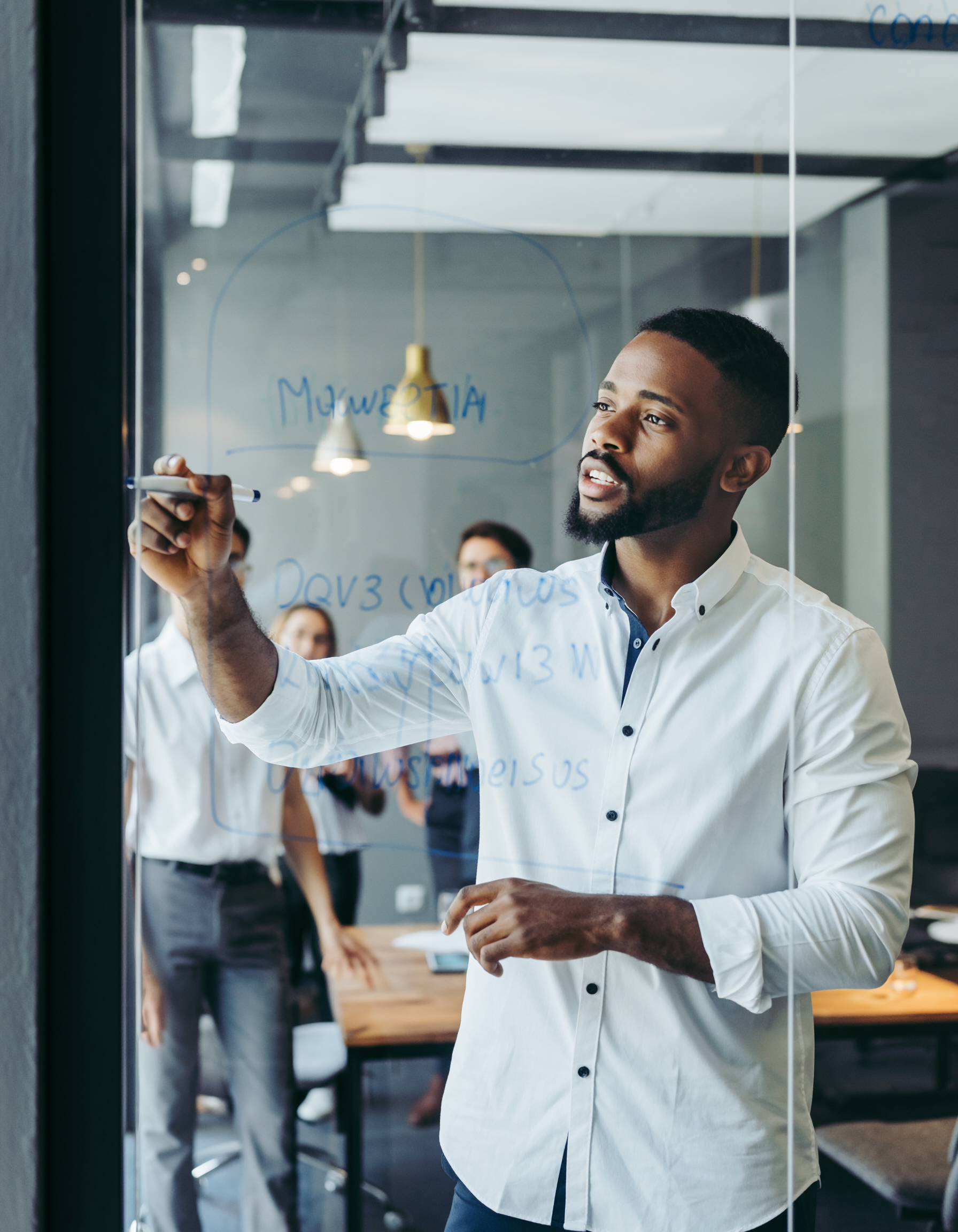 Young Professional Writing on Glass Surface in Modern Office