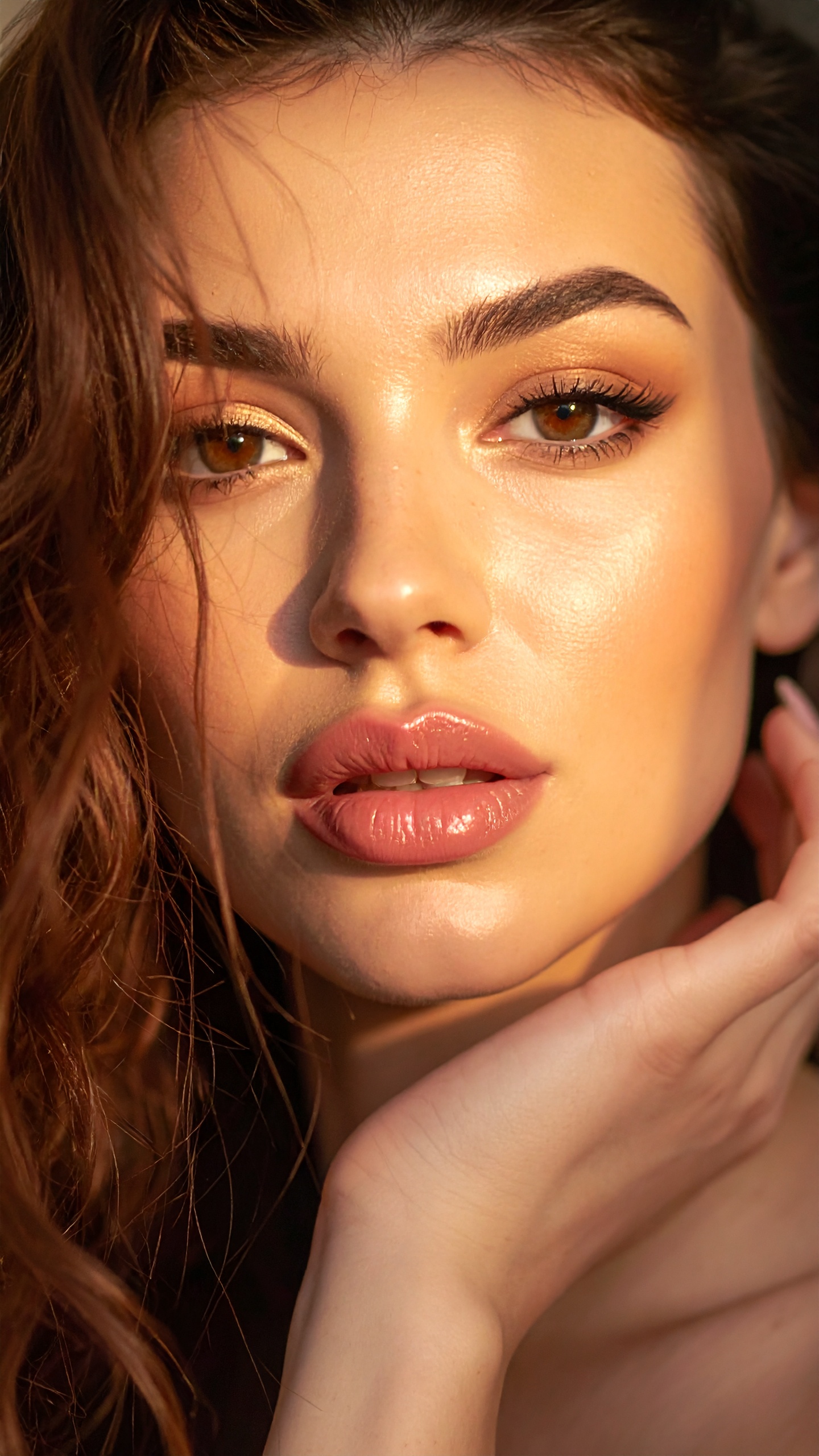 A woman with radiant skin and natural makeup gazes directly at the camera