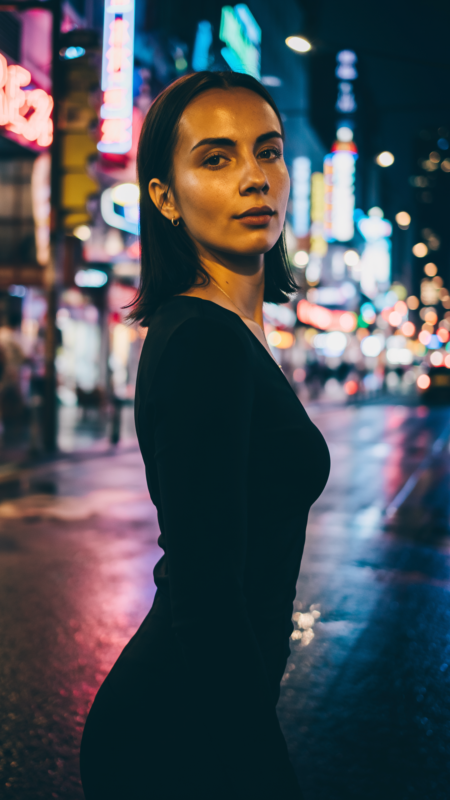 Portrait of a Woman on a Neon-Lit Street at Night
