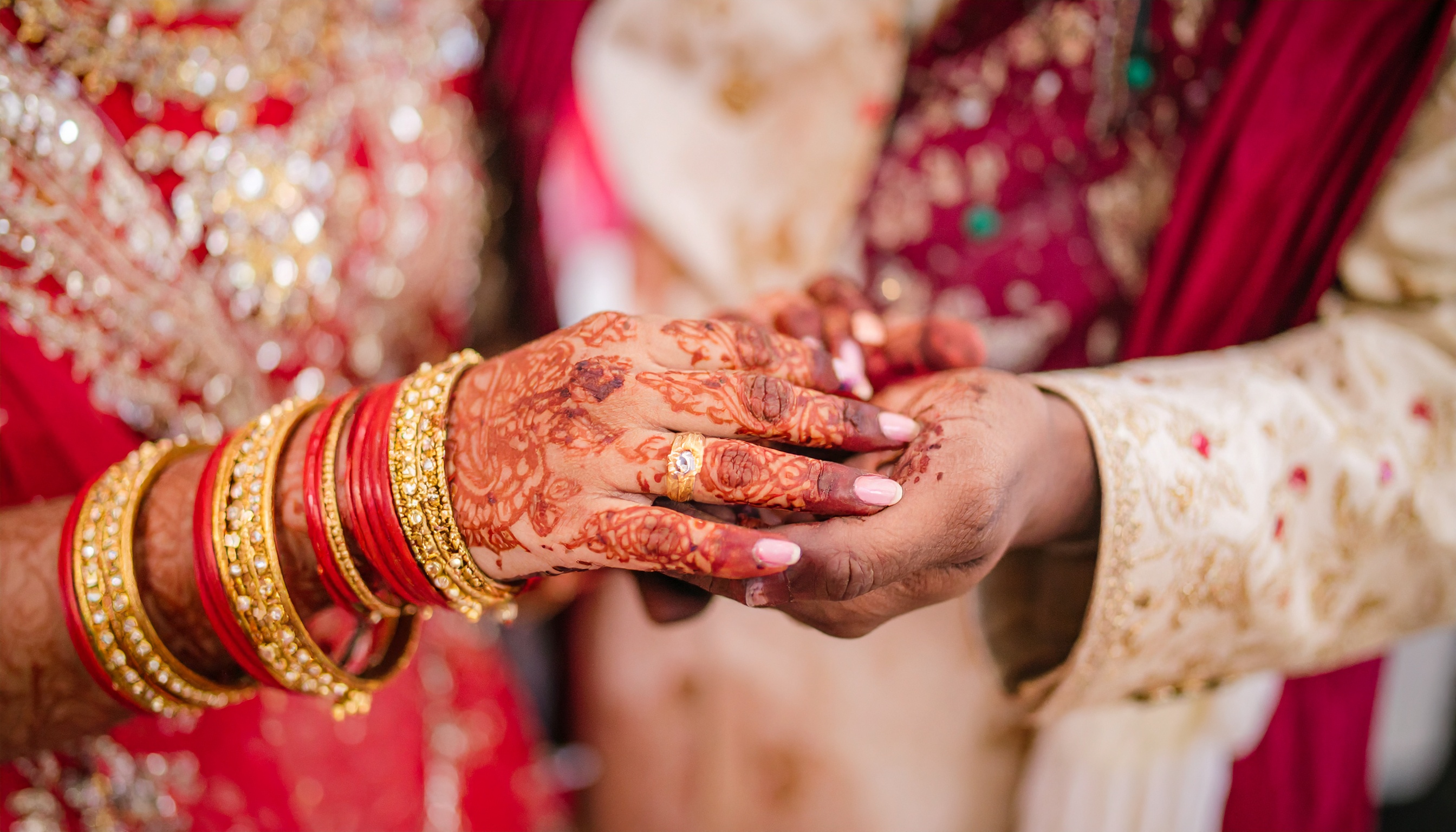 Intricate henna designs adorn hands in a traditional wedding ritual