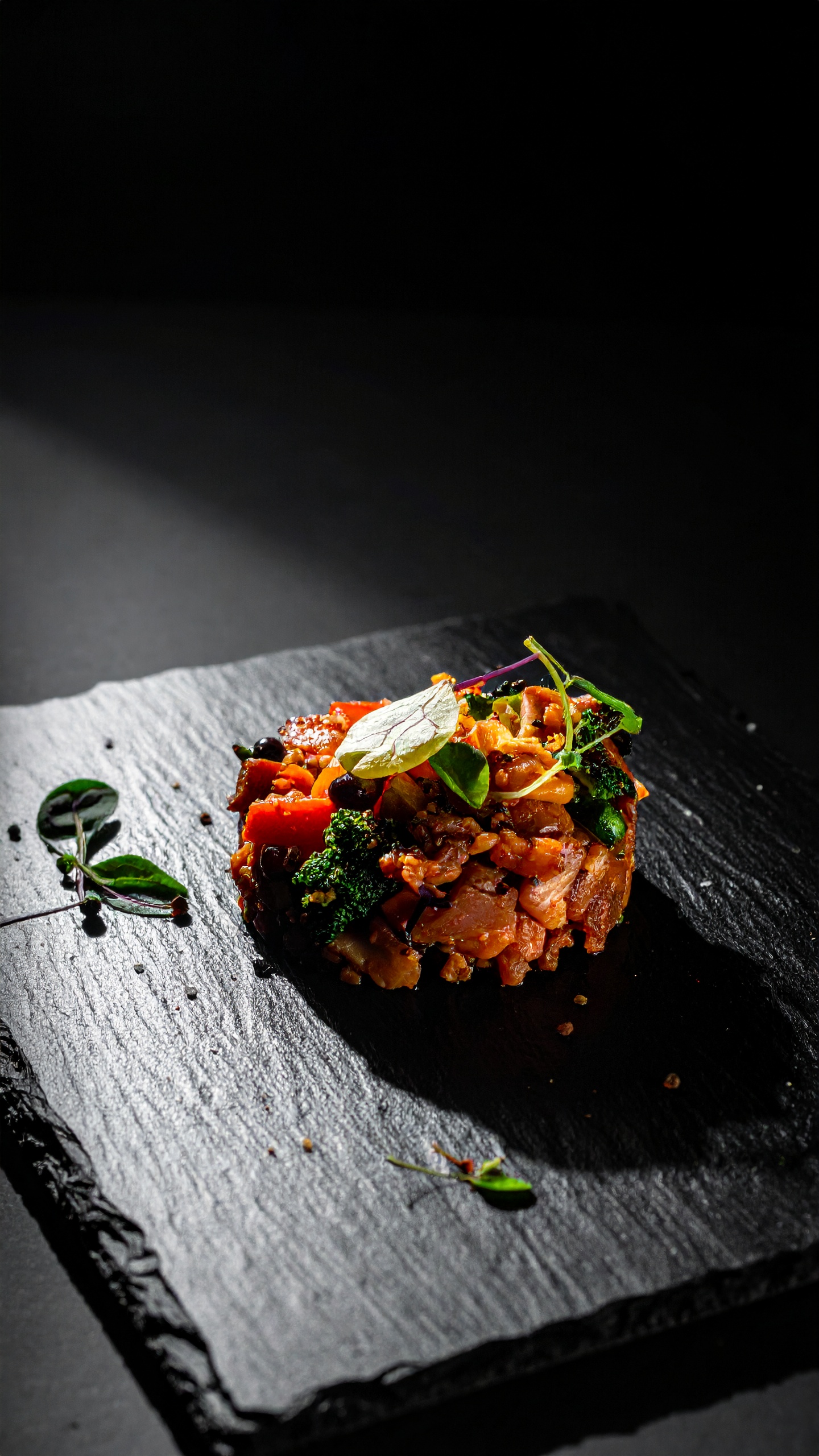 A gourmet dish beautifully presented on a dark slate plate