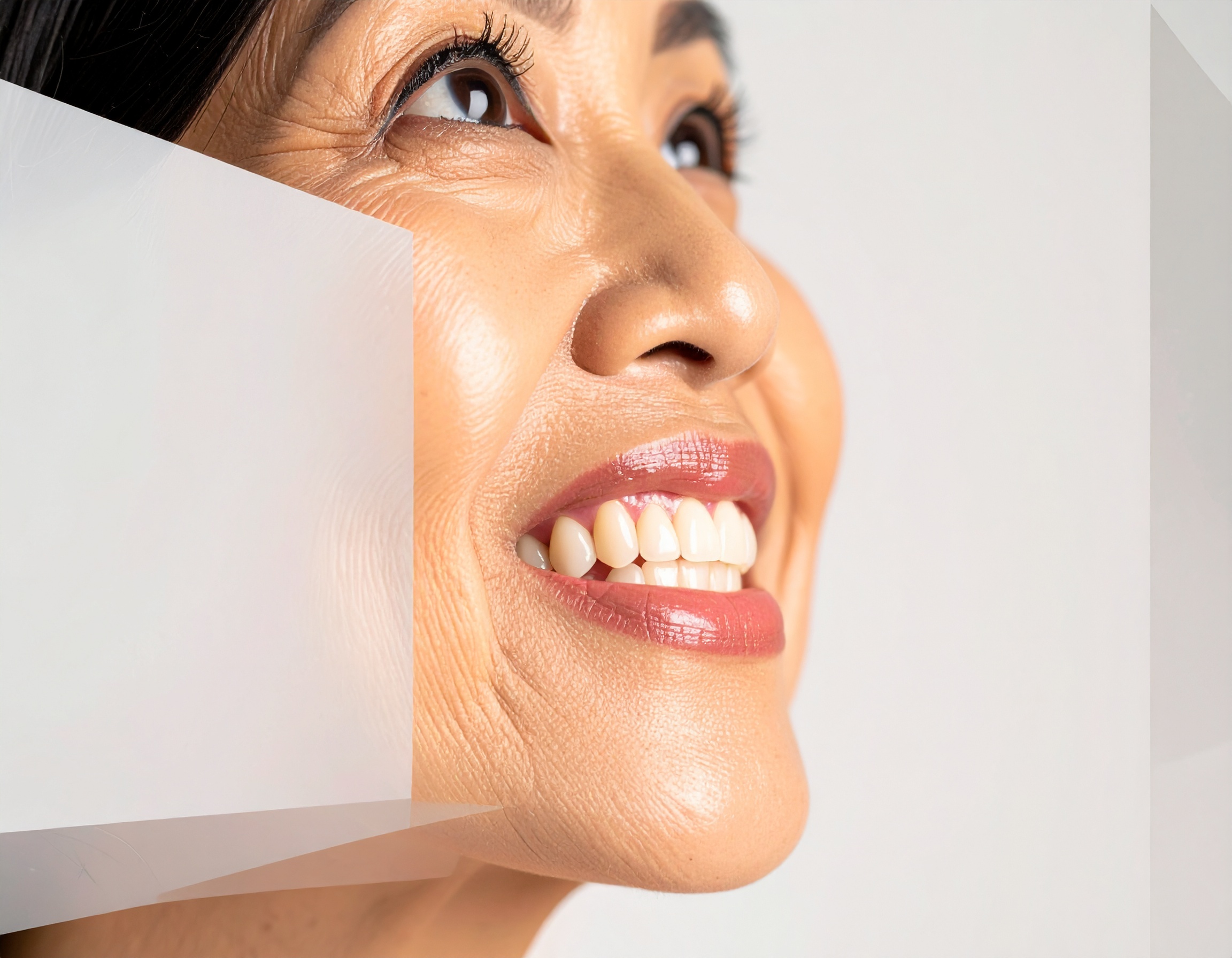 A cheerful woman smiles brightly against a soft background